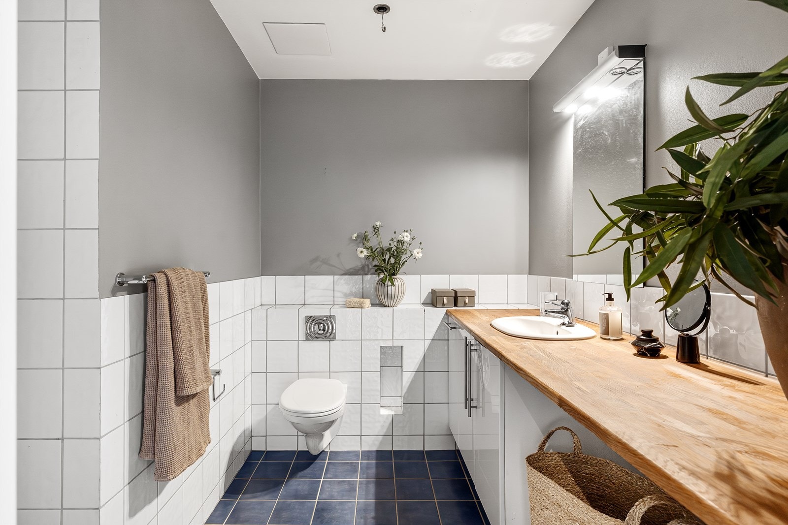 Romslig bad med fliser på gulv og malte overflater på veggene. Badet har gulvvarme og er utstyrt med mekanisk avtrekk, bereder og opplegg for vaskemaskin. Galleribilde