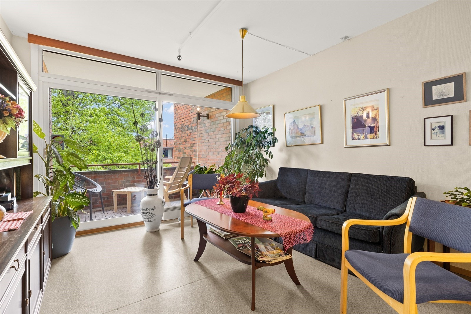 Felles stue til fri bruk for beboere og deres gjester, med balkong og hyggelig utsyn mot atriet Galleribilde