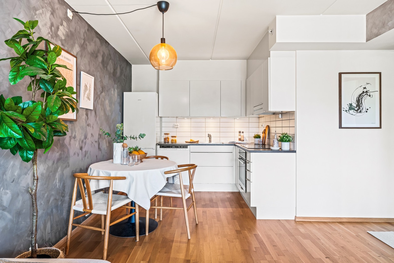 Kjøkkenet har en tidsriktig innredning fra Norema med hvite slette fronter og laminat benkeplate. Galleribilde