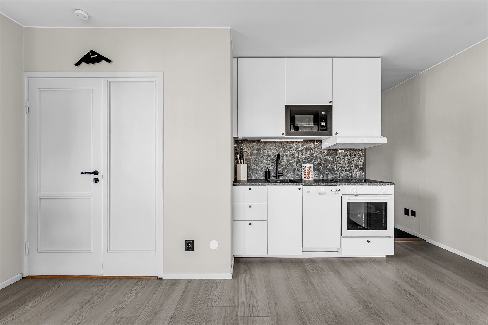 Kjøkkeninnredning med slette fronter og laminert benkeplate, kombinert med sort oppvaskkum og ettgreps blandebatteri. Galleribilde
