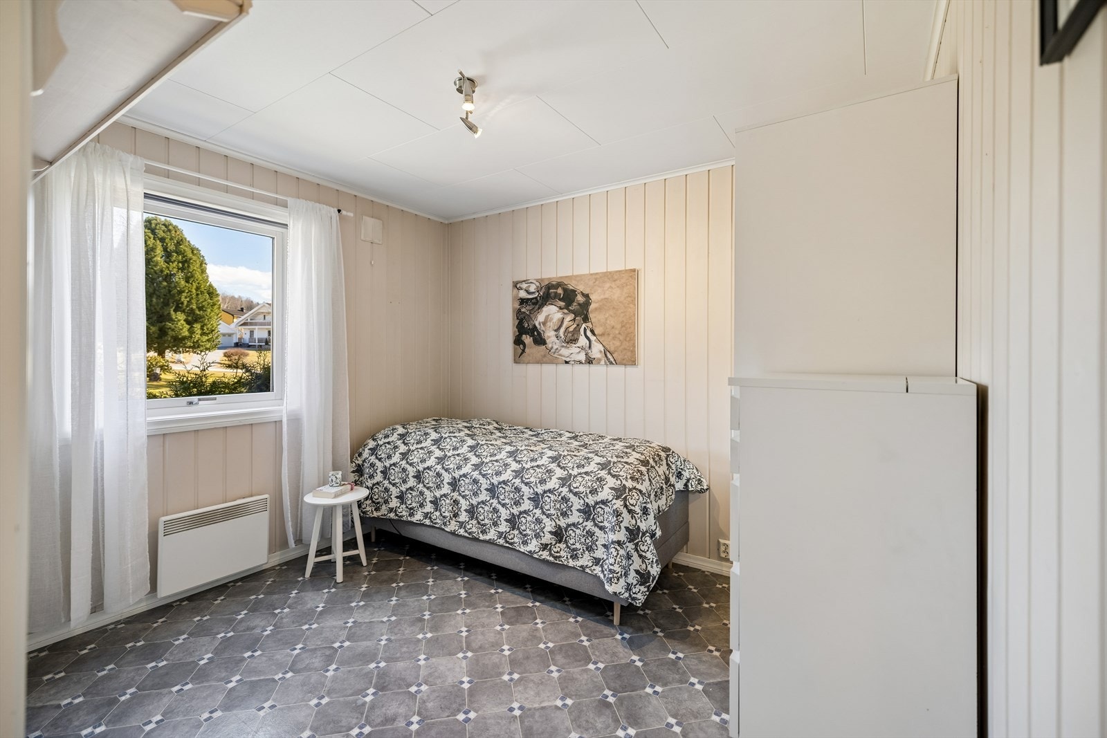 Soverom i første etasje med belegg på gulvet og malt trepanel på veggene. Galleribilde