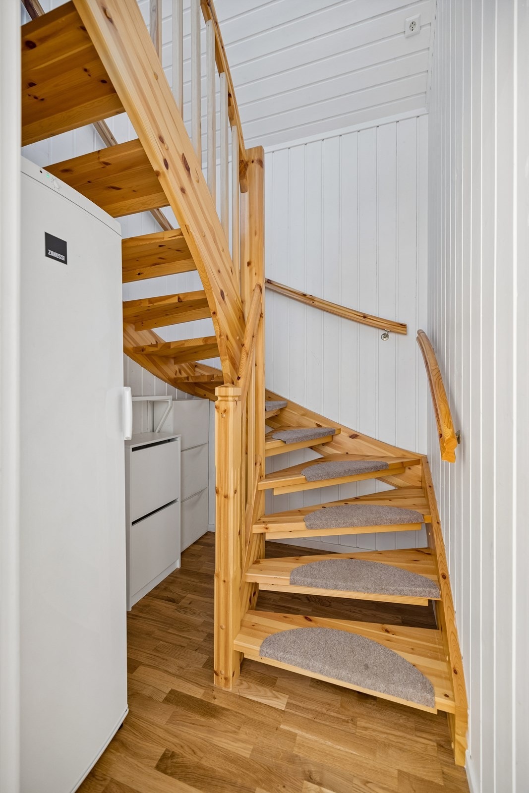 Tretrappen forbinder de to etasjene. Vegger og tak i trappeoppgangen ble malt i 2014. Fryseskapet følger med i salget. Galleribilde
