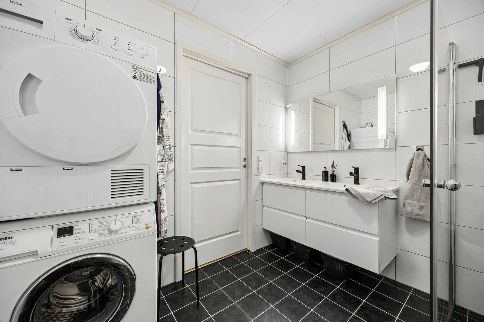 Badet fremstår som romslig og praktisk, med både dobbel servant, dusjhjørne og opplegg for vaskemaskin. Galleribilde