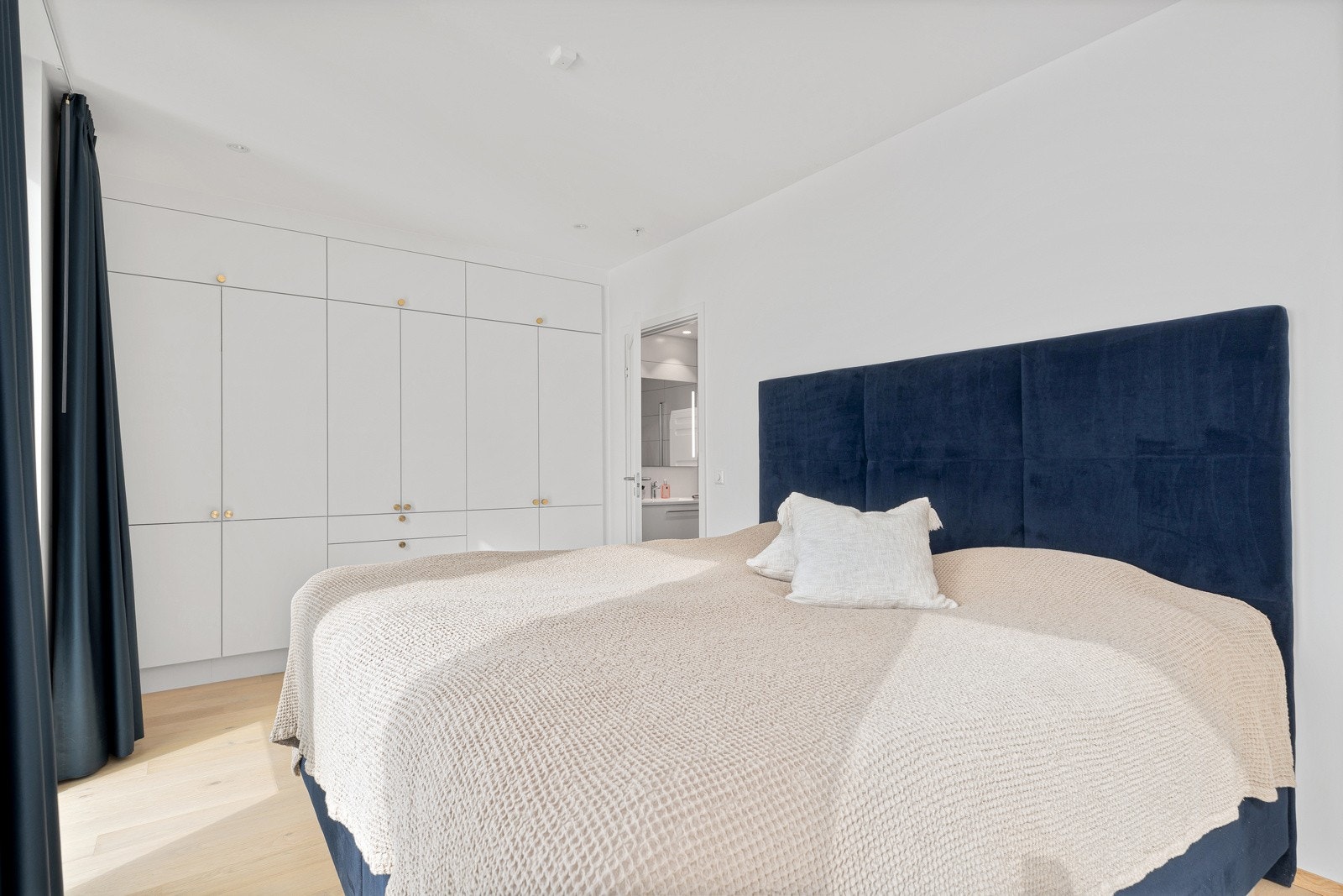 Plassbygde garderobeskap fra gulv til tak og suiteløsning til det største badet. Galleribilde