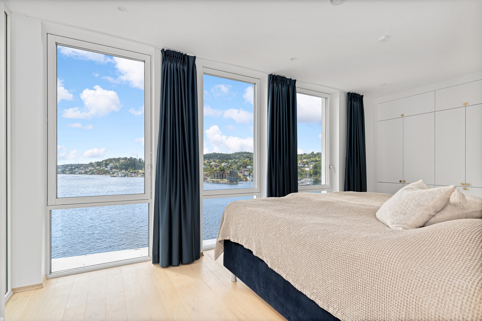 Hovedsoverommet har vestvendte vinduer fra gulv til tak som drar sjøen visuelt inn i rommet. Fastmointert solskjerming sørger for velbehag på sommeren. Galleribilde