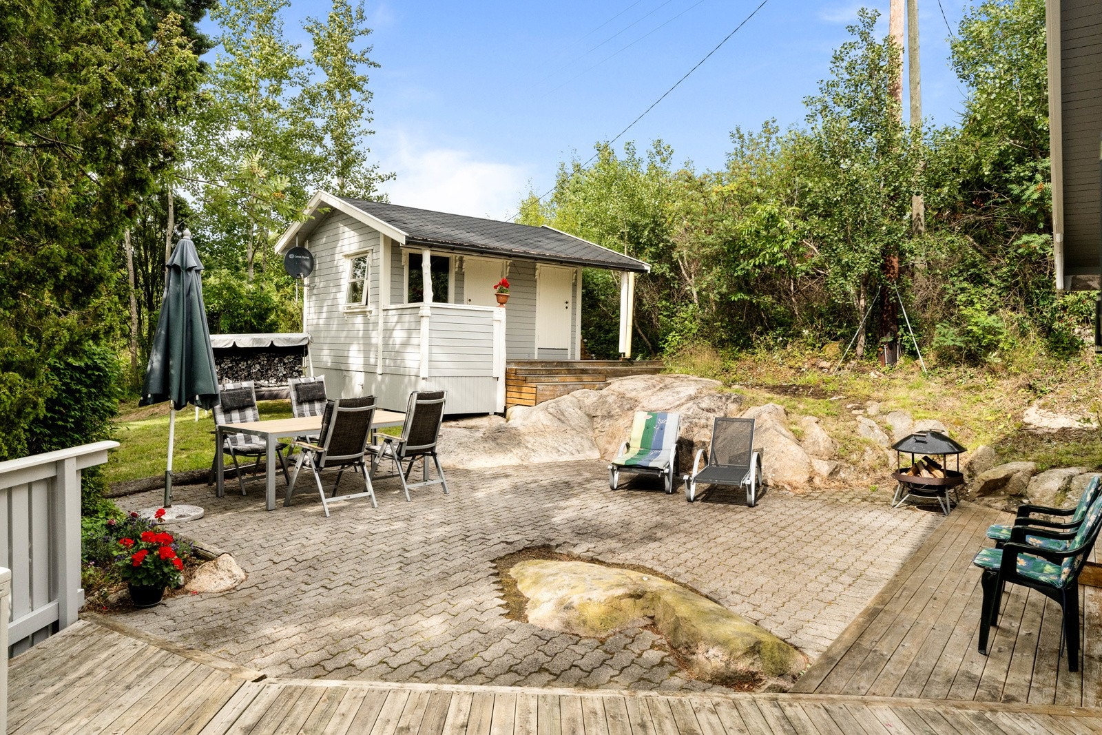 Den store, nordvendte plattingen er steinsatt og går over to nivåer, slik at den ligger tilknyttet både markterrassen og verandaen i vest som har dekke av terrassebord. Galleribilde