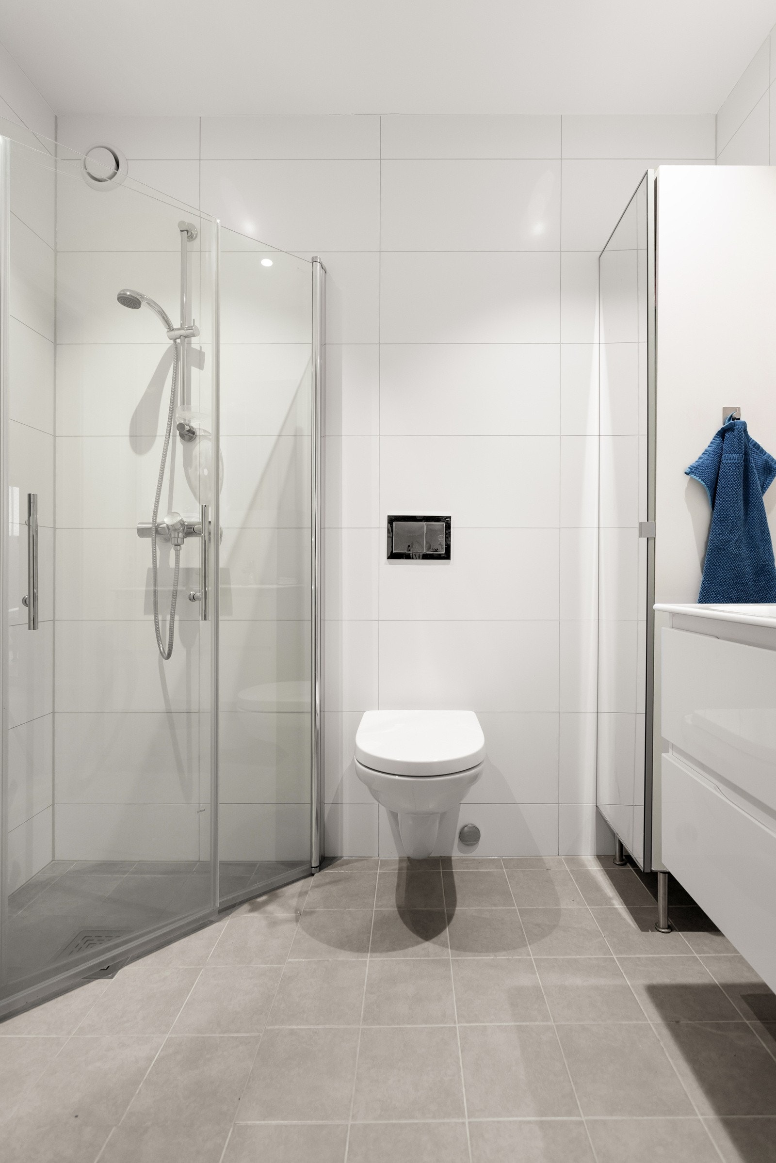 Badet ved soverommet er moderne med flislagte vegger og gulv på betongunderlag Galleribilde