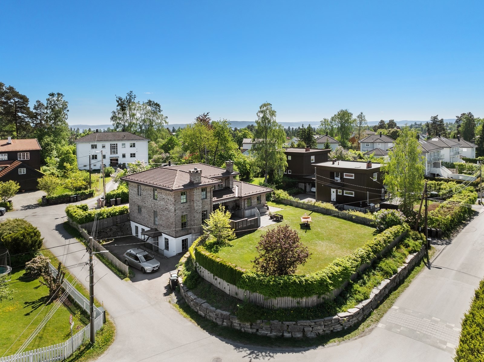 Pent opparbeidet med steinmur, hekk og beplanting. Galleribilde