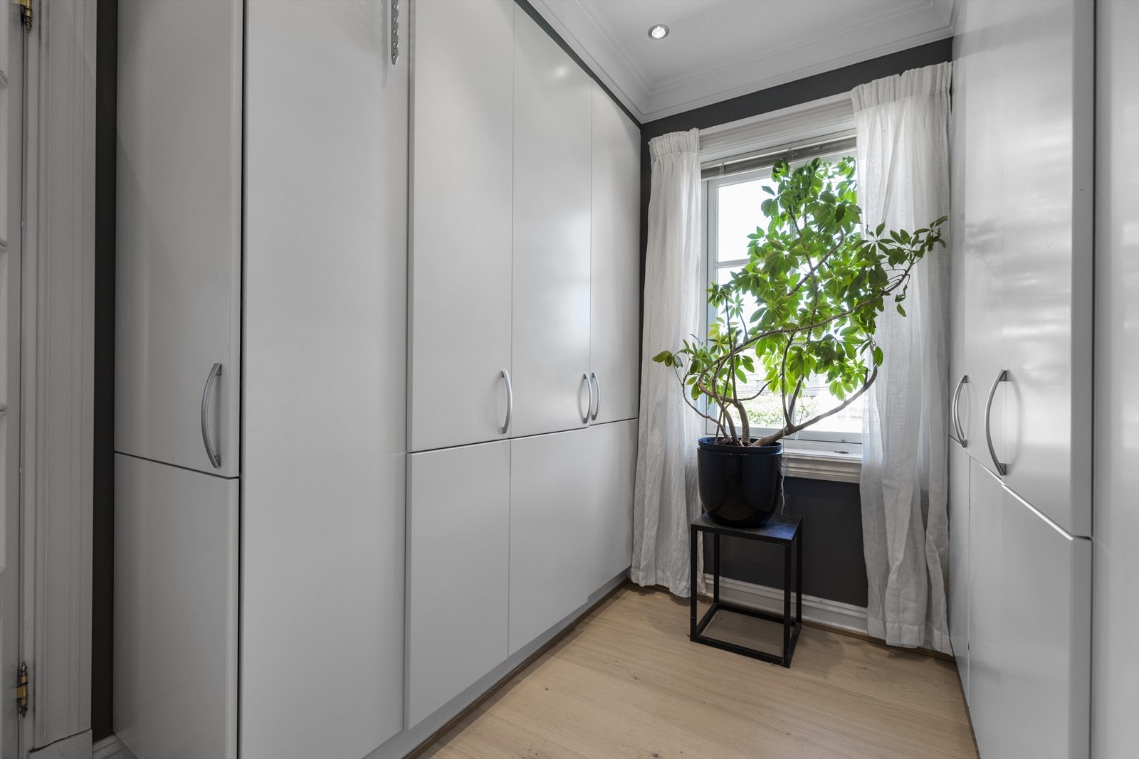 Garderoberom med vindu. Her er all plass utnyttet, med praktisk skoskap på enden. Galleribilde