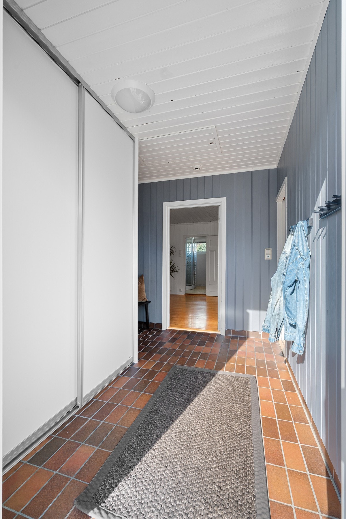 Flislagt entré med gulvvarme og skyvedørsgarderobe for oppbevaring Galleribilde