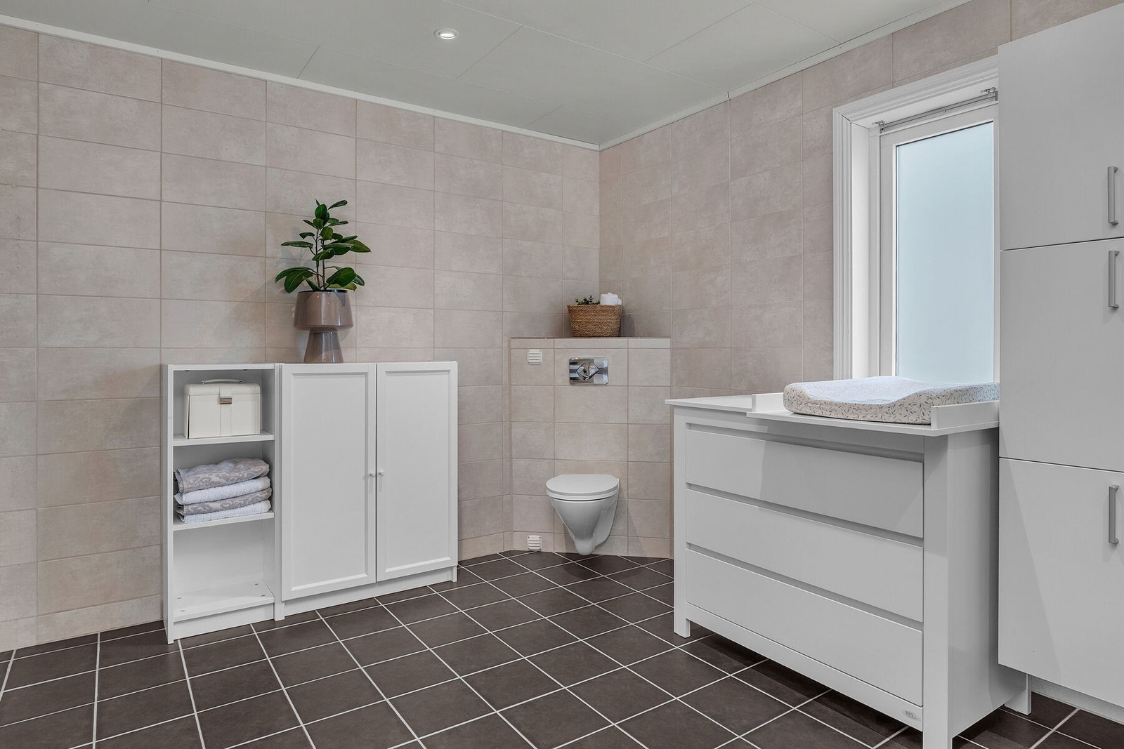 Badet er flislagt i tidløse toner som skaper en rolig og harmonisk atmosfære. Det er i tillegg behagelig gulvvarme. Galleribilde