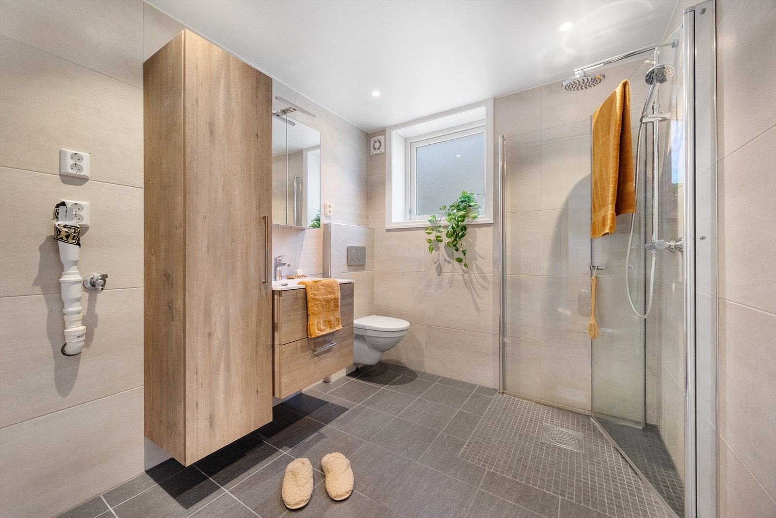 Badet er helfliset, har varmekabler i gulv og opplegg for både vaskemaskin og tørketrommel. Vindu som kan åpnes gir bedre lufting og ventilasjon samt bevarelse av baderommet. Galleribilde