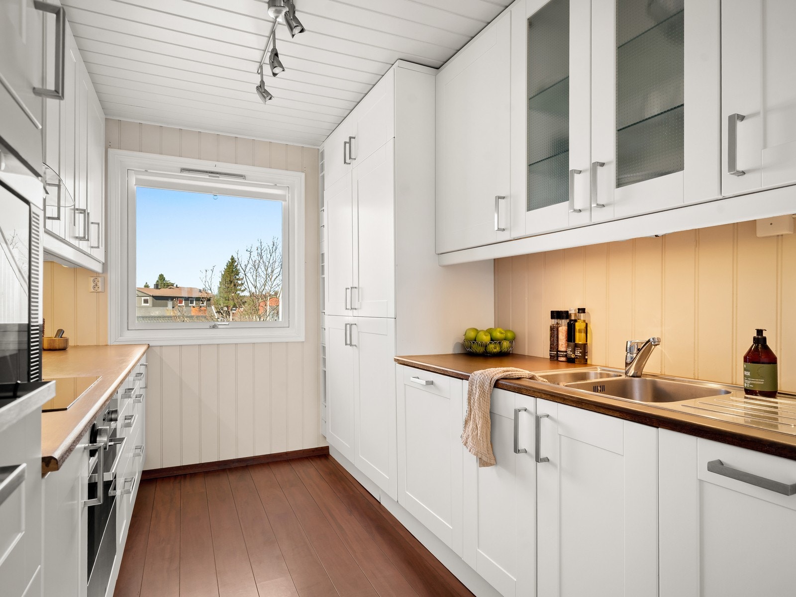 Pen kjøkkeninnredningen fra 2008 med hvite, profilerte fronter og en solid benkeplate i heltre. Galleribilde