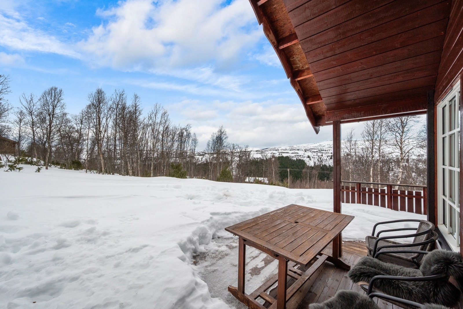 Det er en romslig terrasse med utsikt over fjellene. Galleribilde