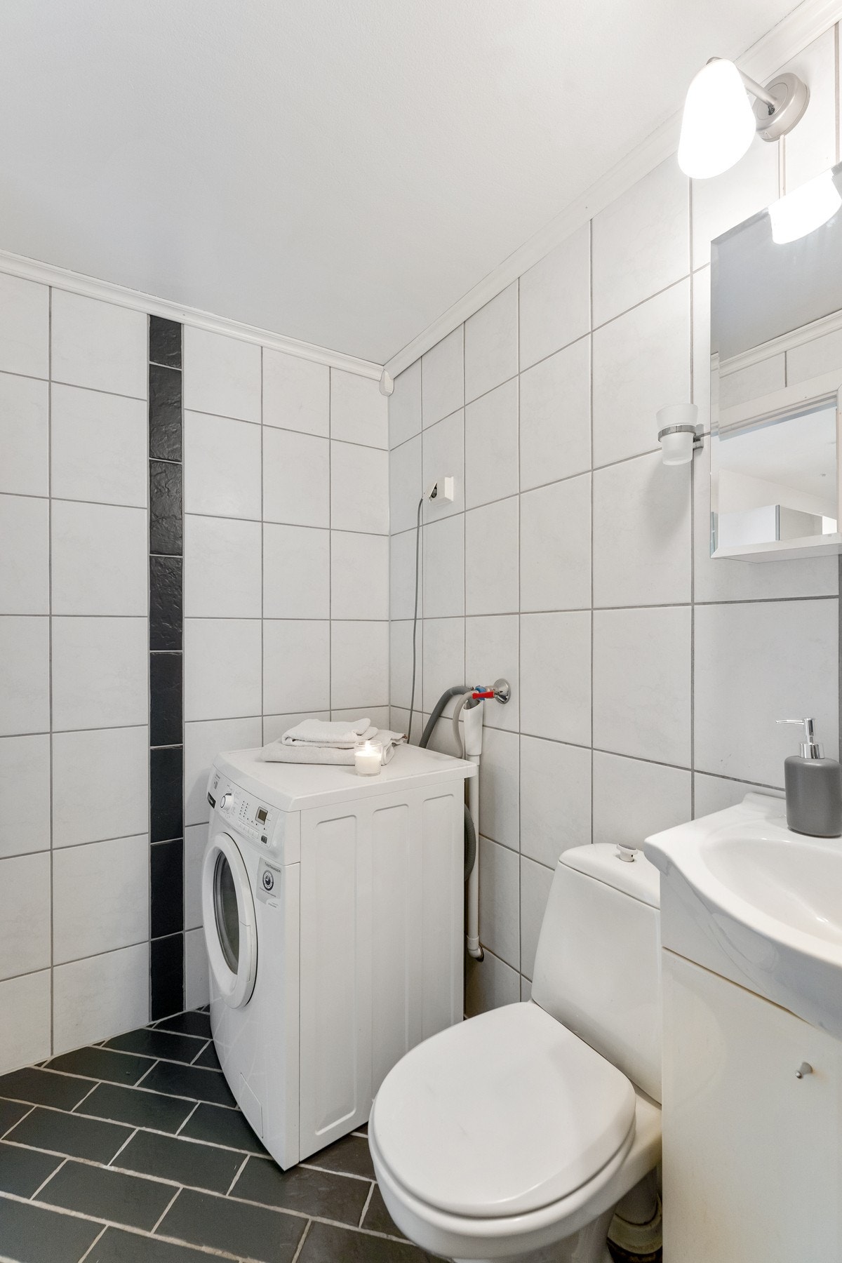 Badet er utstyrt med dusjkar, baderomsinnredning med speil og gulvstående toalett. Det er opplegg for vaskemaskin. Galleribilde