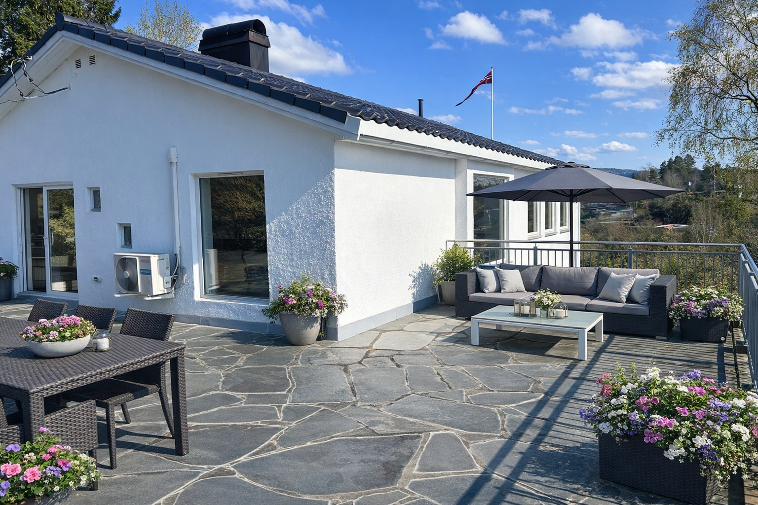 Stor hellelagt uteplass med adkomst fra stue. Flott utsikt og optimale solforhold. Bilde er KI-generert fra vinter til sommer. Avvik kan forekomme. Galleribilde