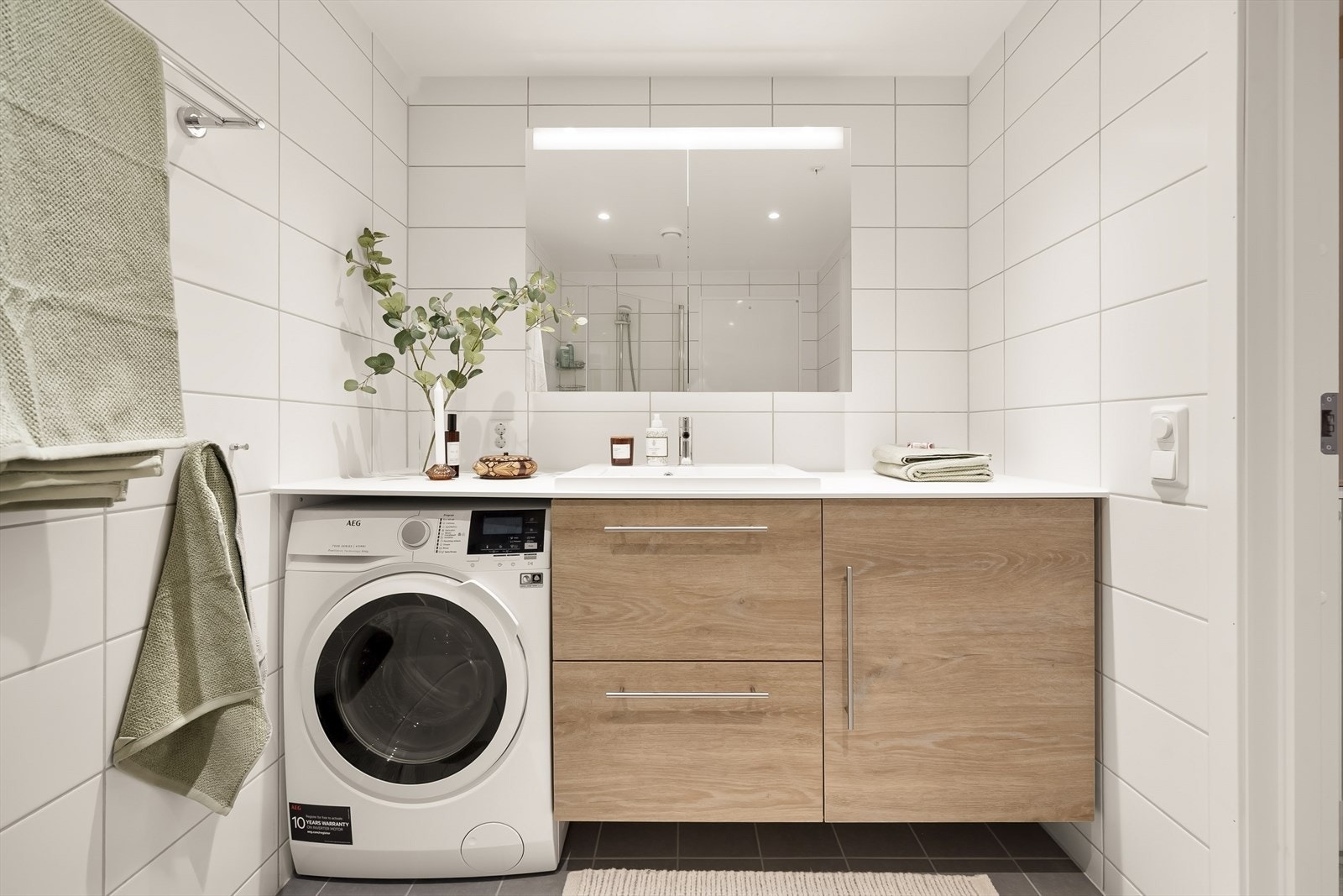 Badet er utstyrt med servantinnredning, speilskap og opplegg for vaskemaskin. Galleribilde