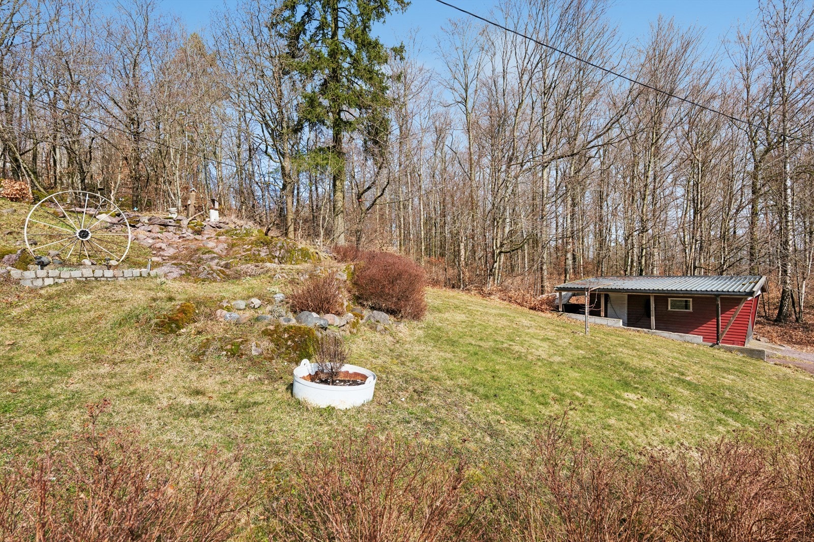 Eiertomten på 1327m² ligger i et skrånende terreng med skogen som nærmeste nabo på baksiden. Galleribilde