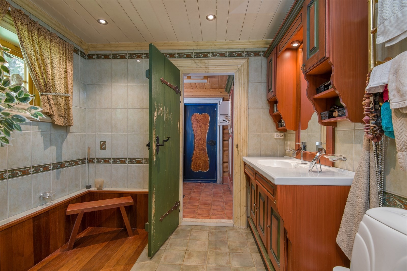 Flislagt bad i 1.etg. som er innredet med romslig dusjnisje, gulvmontert toalett og heltre baderomsrinnredning med heldekkende servantplate og god skapplass. Vaskerom innenfor, med dør ut til hagen. Galleribilde