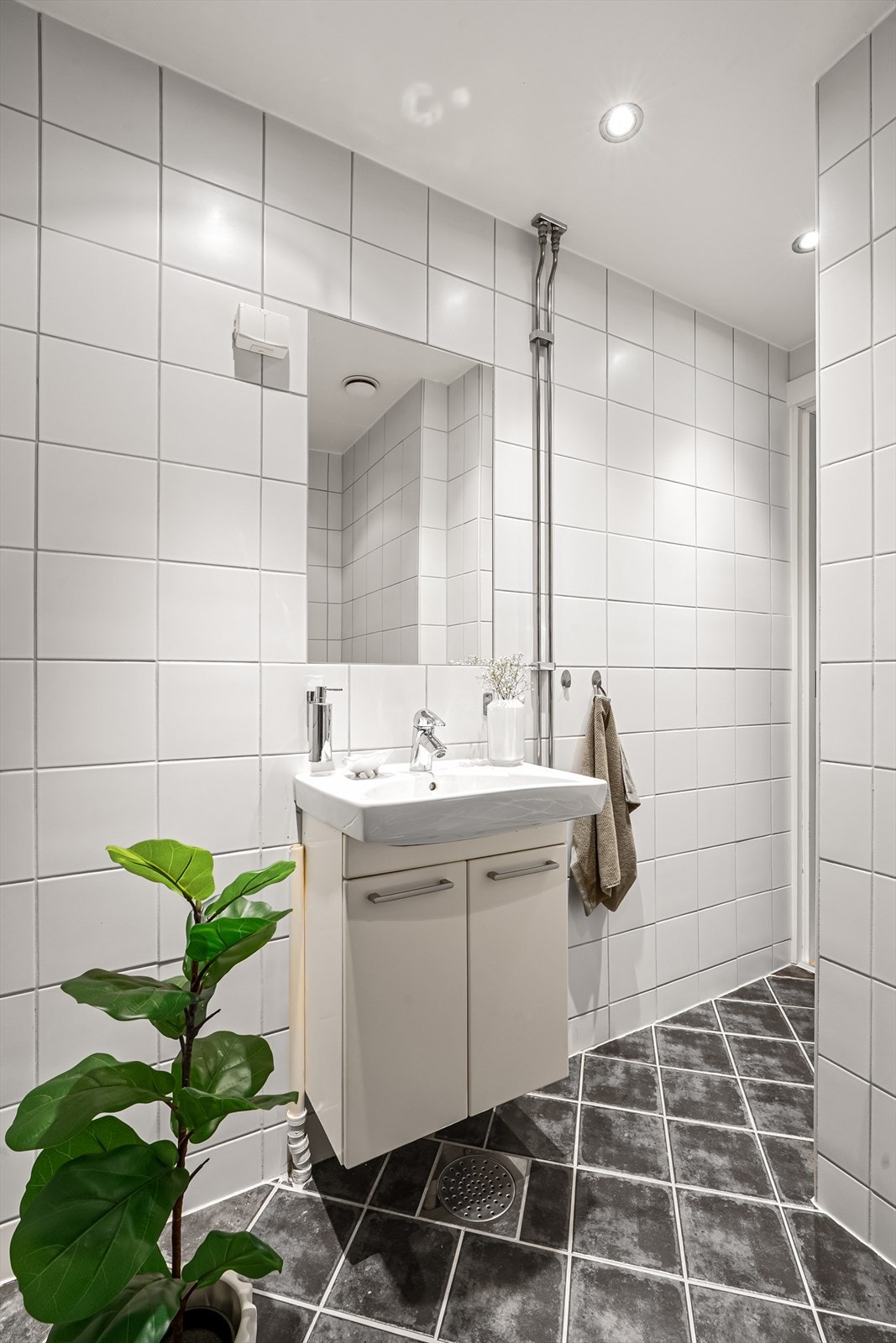 Baderommet har flislagte overflater med varme i gulv og downlights i himling Galleribilde