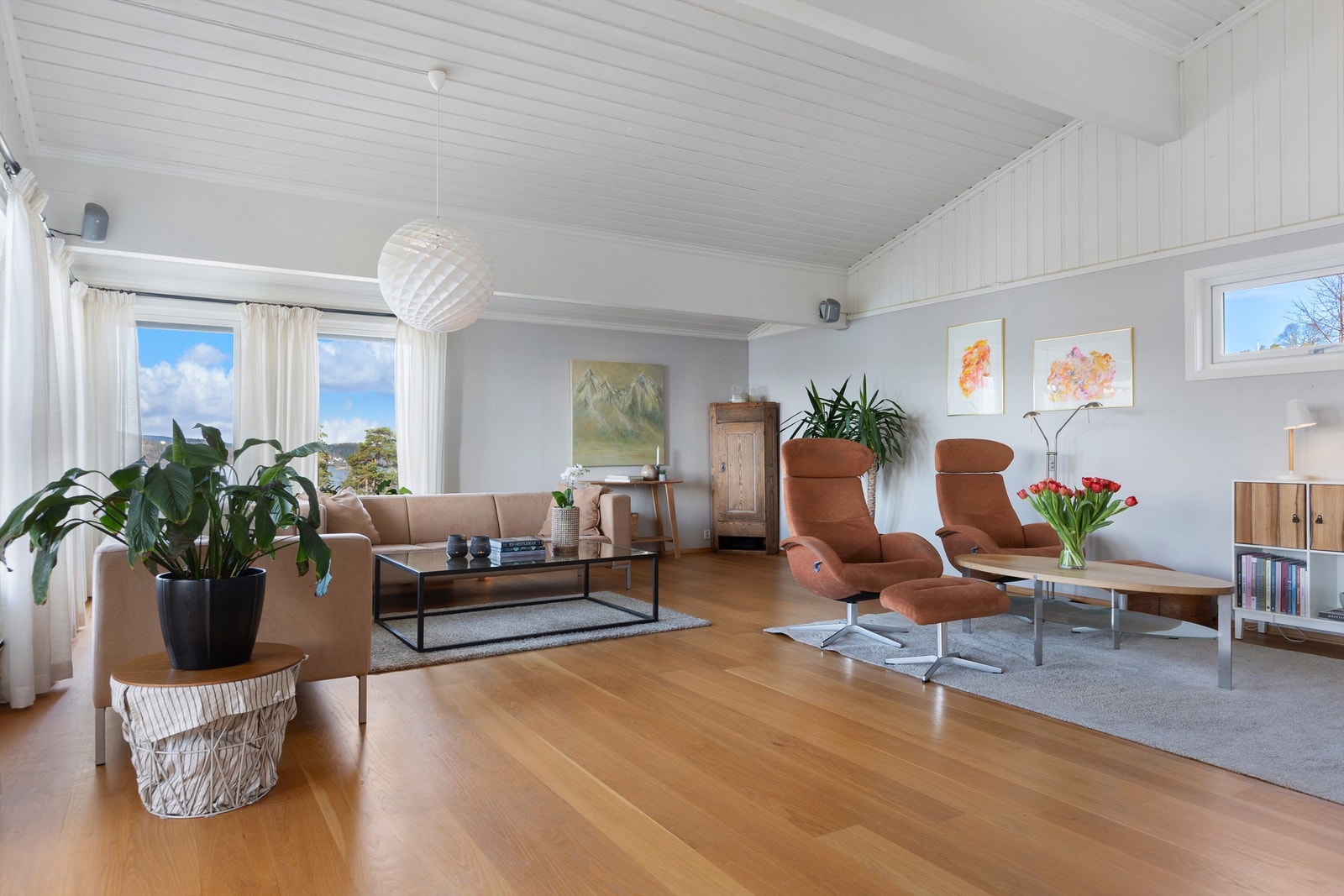 Den romslige stuen har parkettgulv og store vindusflater som slipper inn rikelig med lys. Galleribilde