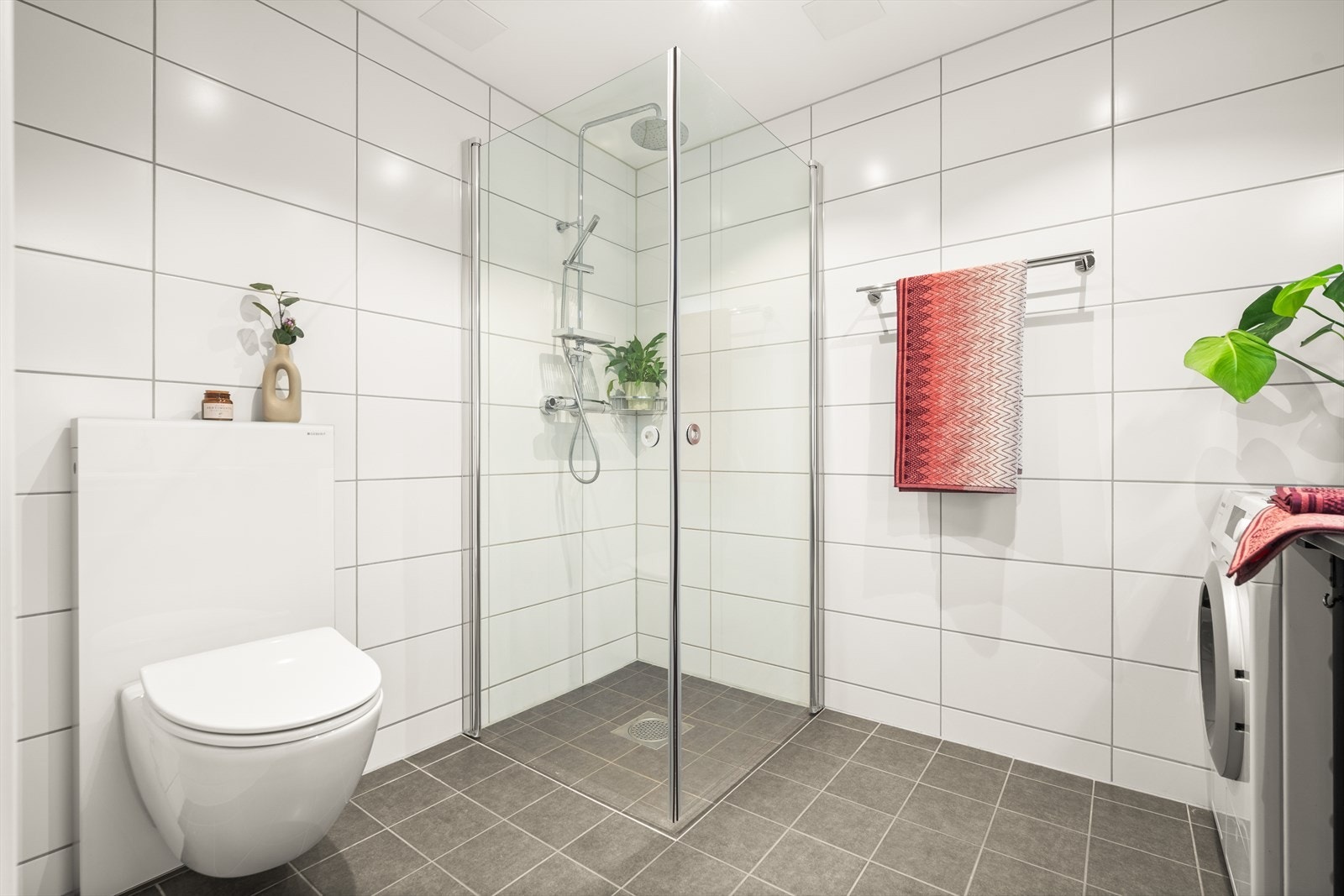 Badet er har mekanisk avtrekk, opplegg for vask/tørke, det er veggmontert wc med utenpåliggende sisterne, dusjhjørne med innfellbare dusjdører og ett-greps batteri i rustfritt stål med 2 dusjhoder fra FM Mattsson. Galleribilde