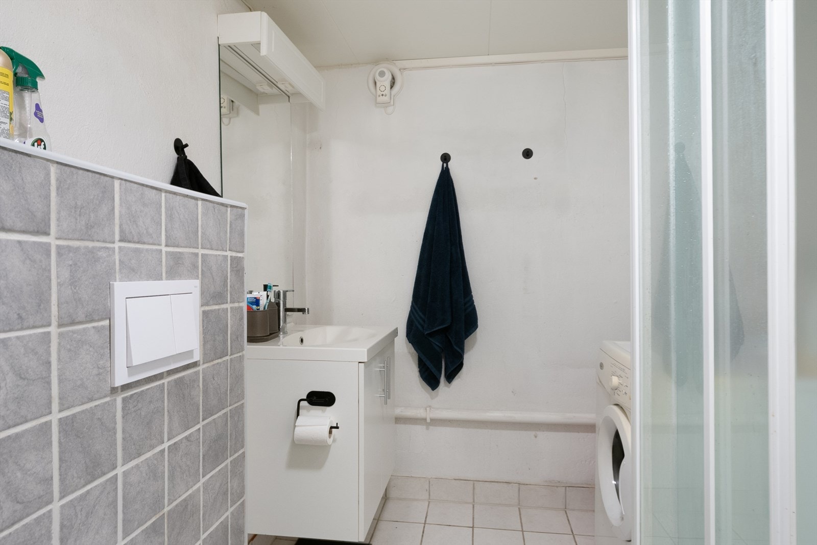 Bad i kjeller med fliser på gulv, malt mur og noe malte plater på vegger, malte plater i himling. Galleribilde