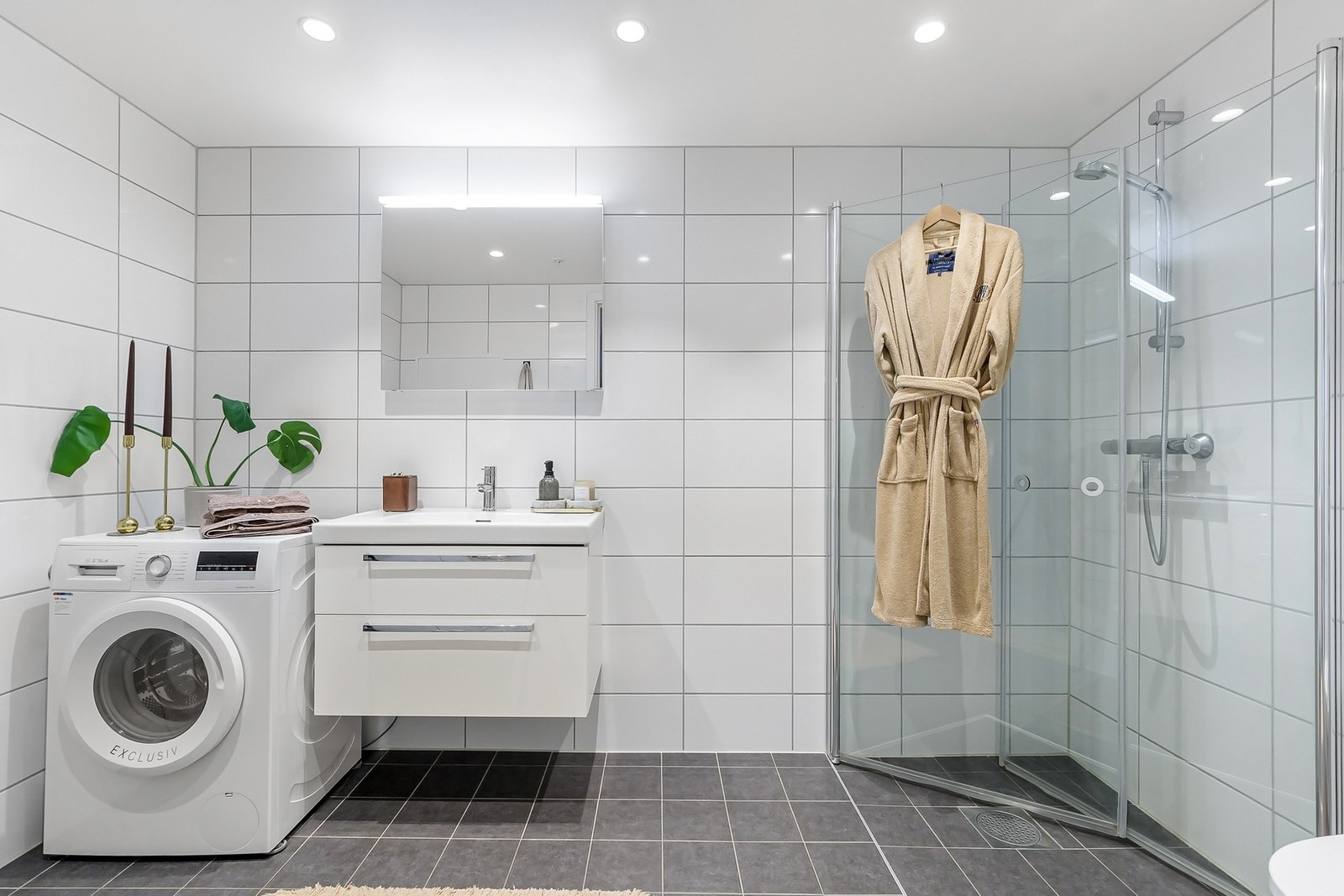 Delikat og flislagt bad med moderne standard. Badet er utstyrt med gulvvarme, veggmontert klosett, dusjhjørne med glassdører og servantinnredning med gode oppbevaringsmuligheter. Galleribilde