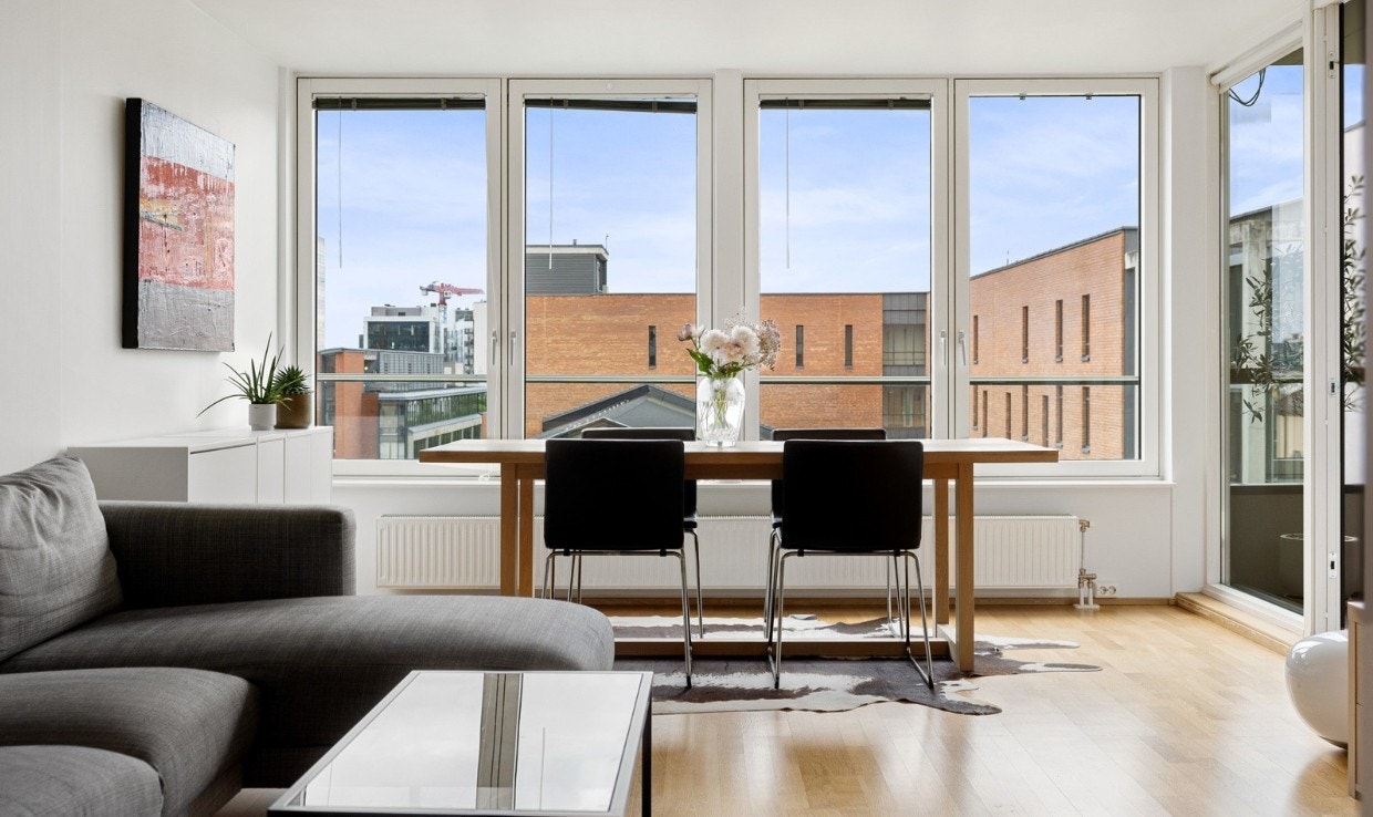 Stue med store flotte vinduer som slipper inn mye lys Galleribilde