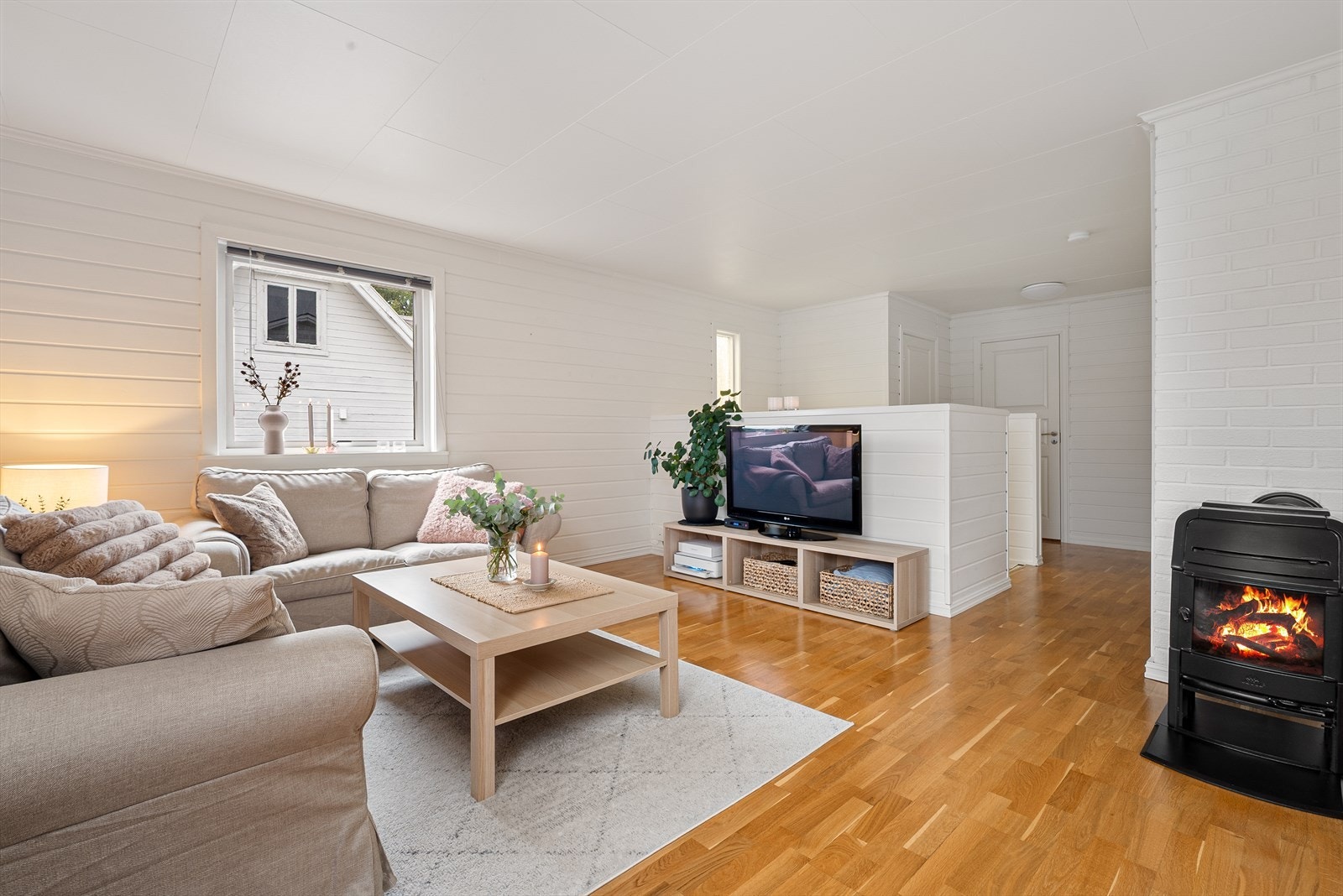Lysmalt stue med god plass til sofagruppe og spisebord. Galleribilde