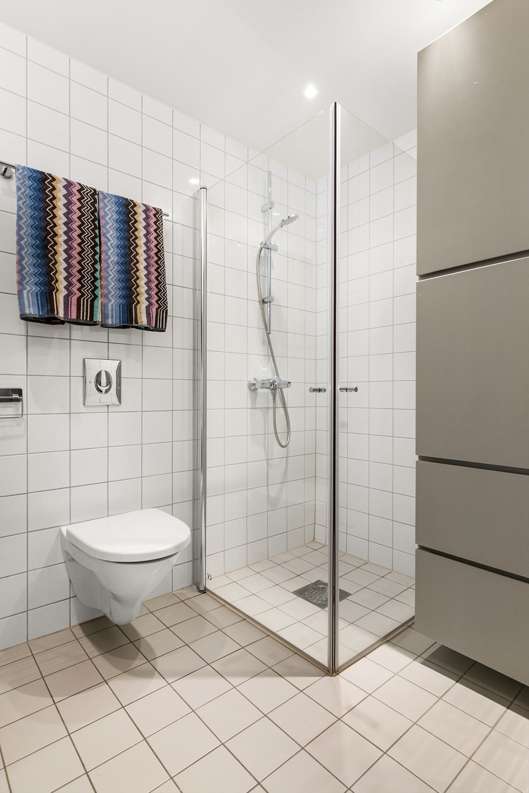Badet er utstyrt med dusjhjørne med innfellbare glassdører. Galleribilde