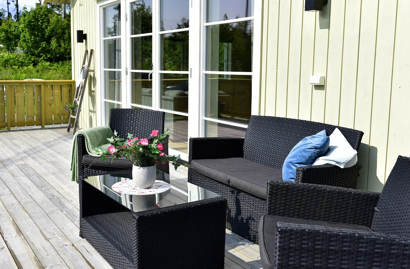 Stor terrasse med plass for flere sittegrupper, grill og solsenger. Galleribilde