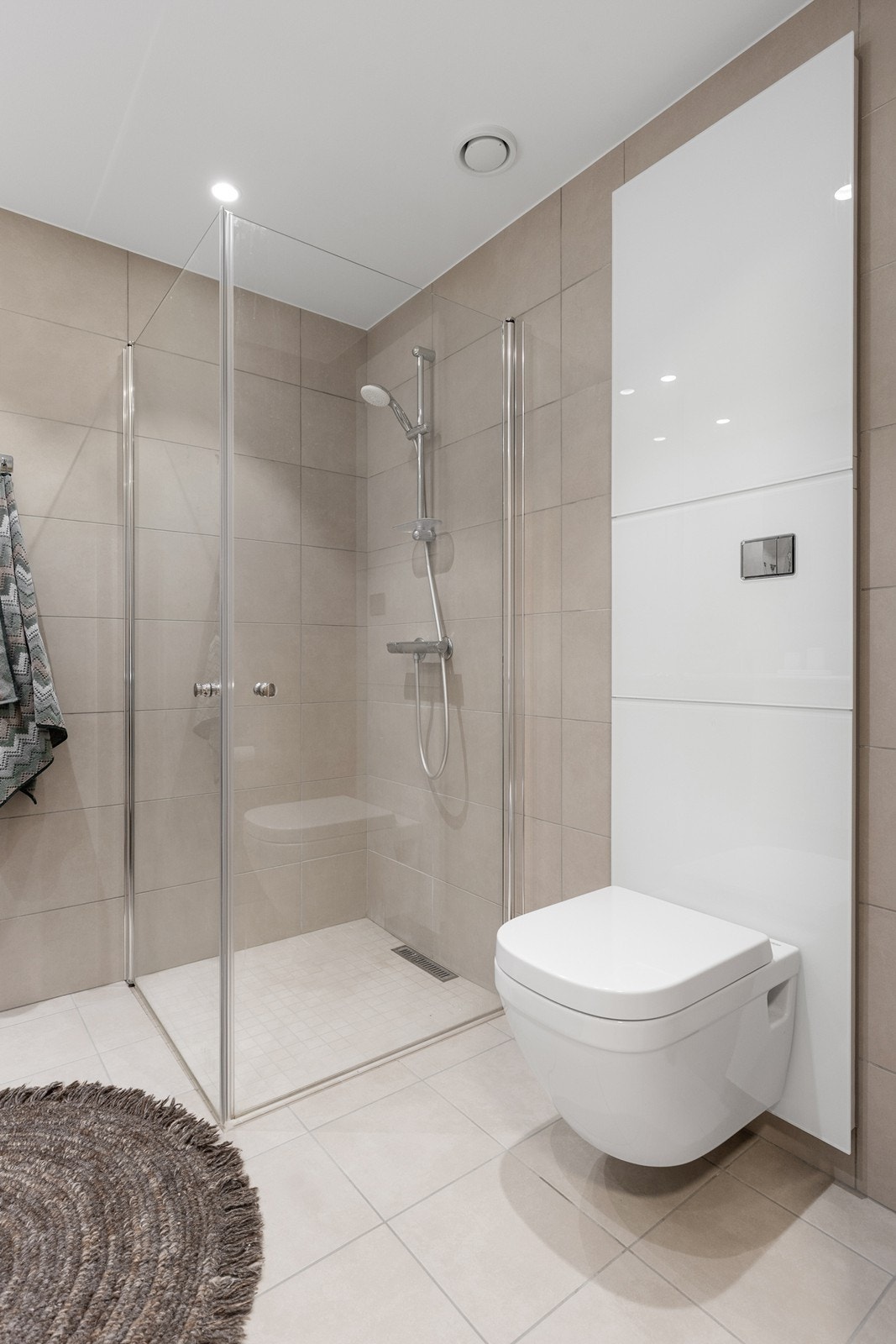 Badet er utstyrt med dusjnisje med stillbare dører i glass samt vegghengt wc. Galleribilde