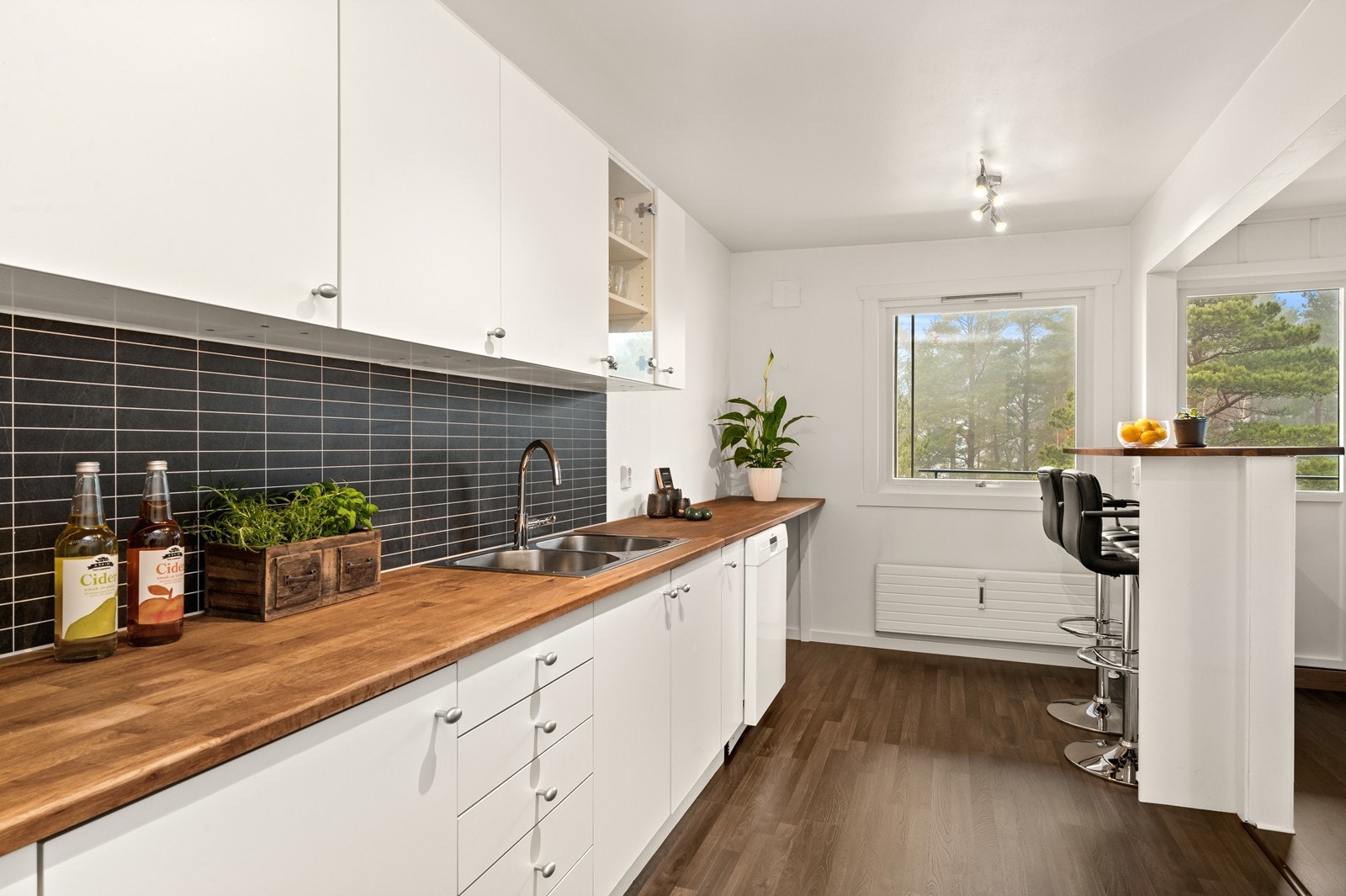 Leiligheten har et moderne kjøkken med glatte fronter og en solid benkeplate i heltre. Galleribilde