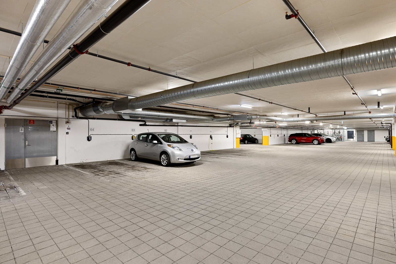 Leiligheten disponerer en garasjeplass med el-bil lader, merket med nr. 64. Galleribilde