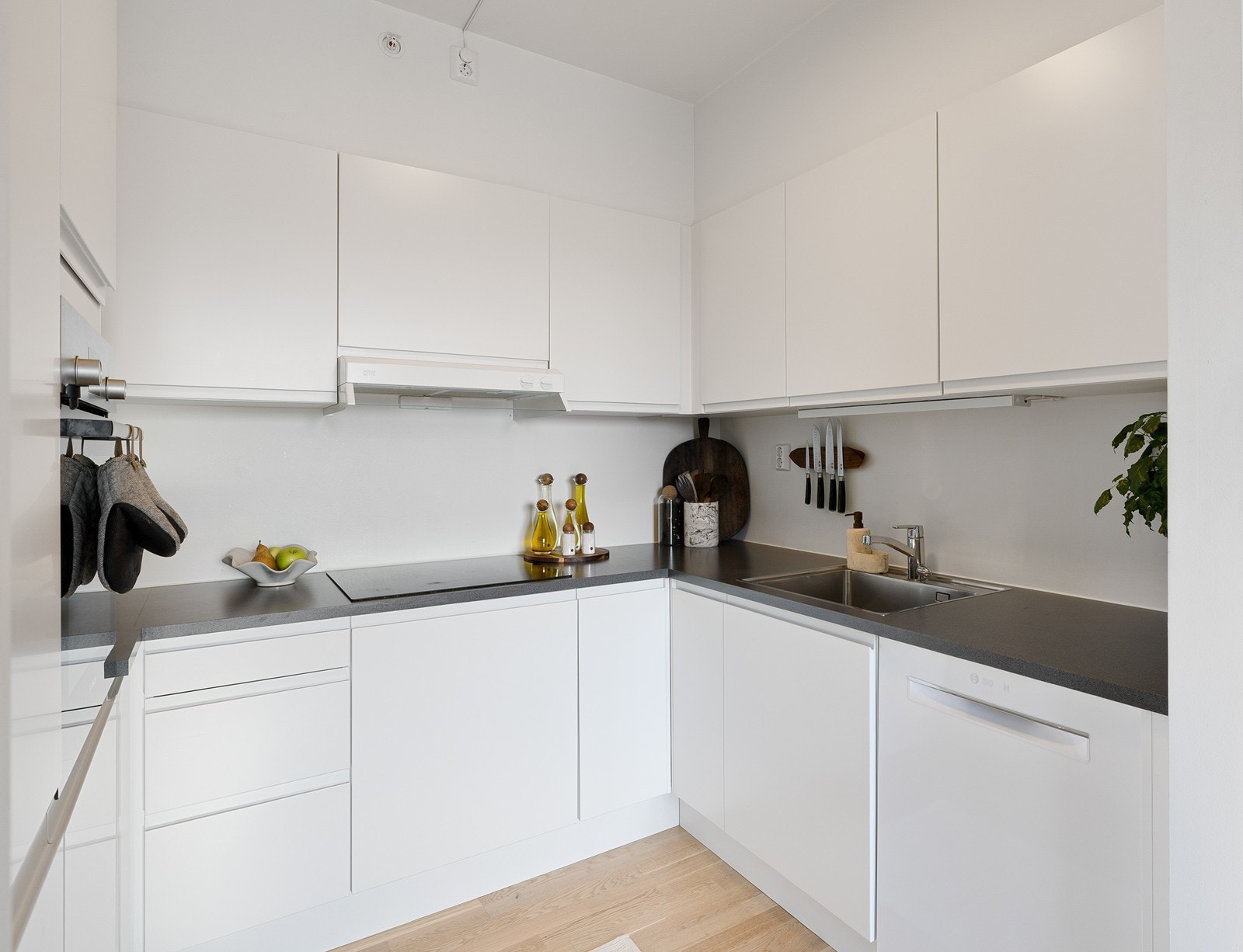 Kjøkkenet er fullt utstyrt med integrerte hvitevarer, inkludert stekeovn i praktisk arbeidshøyde, induksjonstopp med minimalistisk ventilator over, samt oppvaskmaskin og kjøle-/fryseskap. Galleribilde