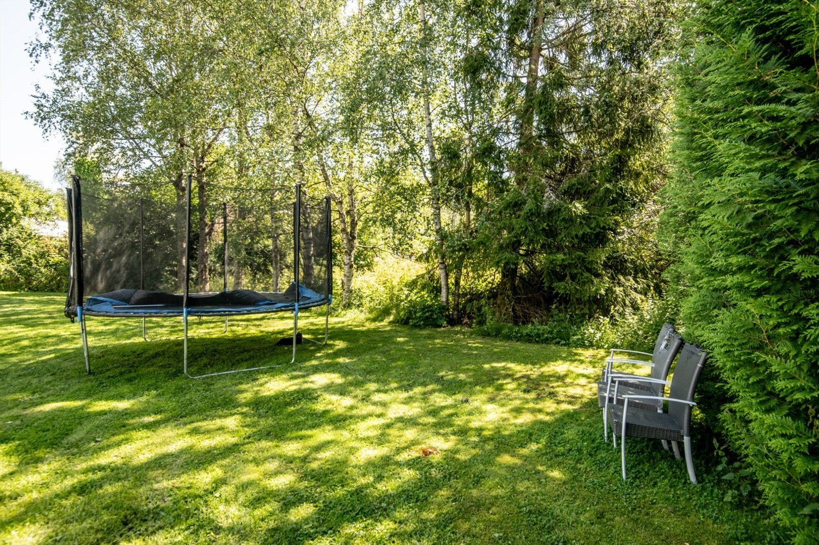 Andelen disponerer en stor, felles hage sammen med de øvrige boenhetene. Selgers sommerbilde. Galleribilde