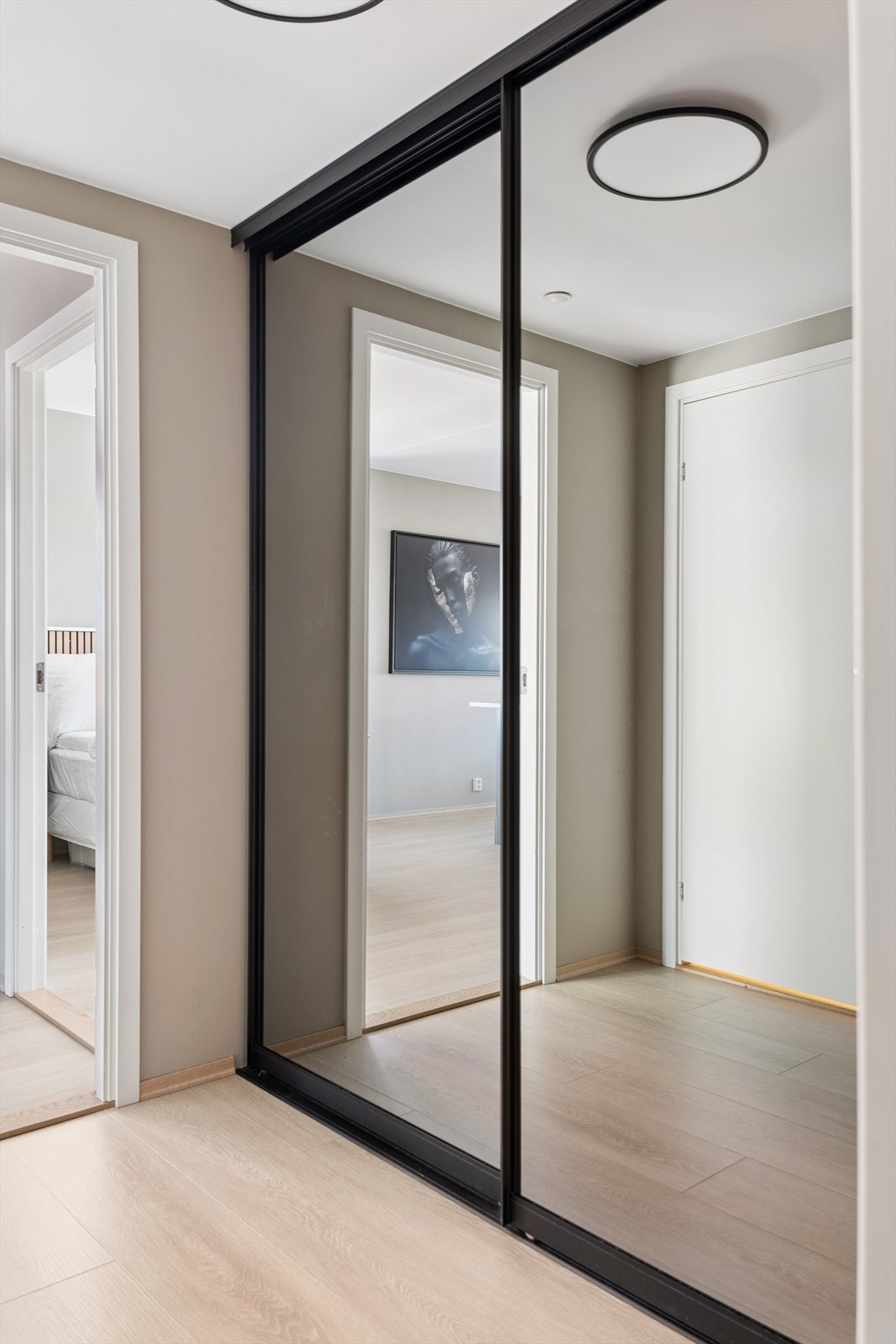 I entreen er det en praktisk skyvedørsgarderobe med speilfronter Galleribilde