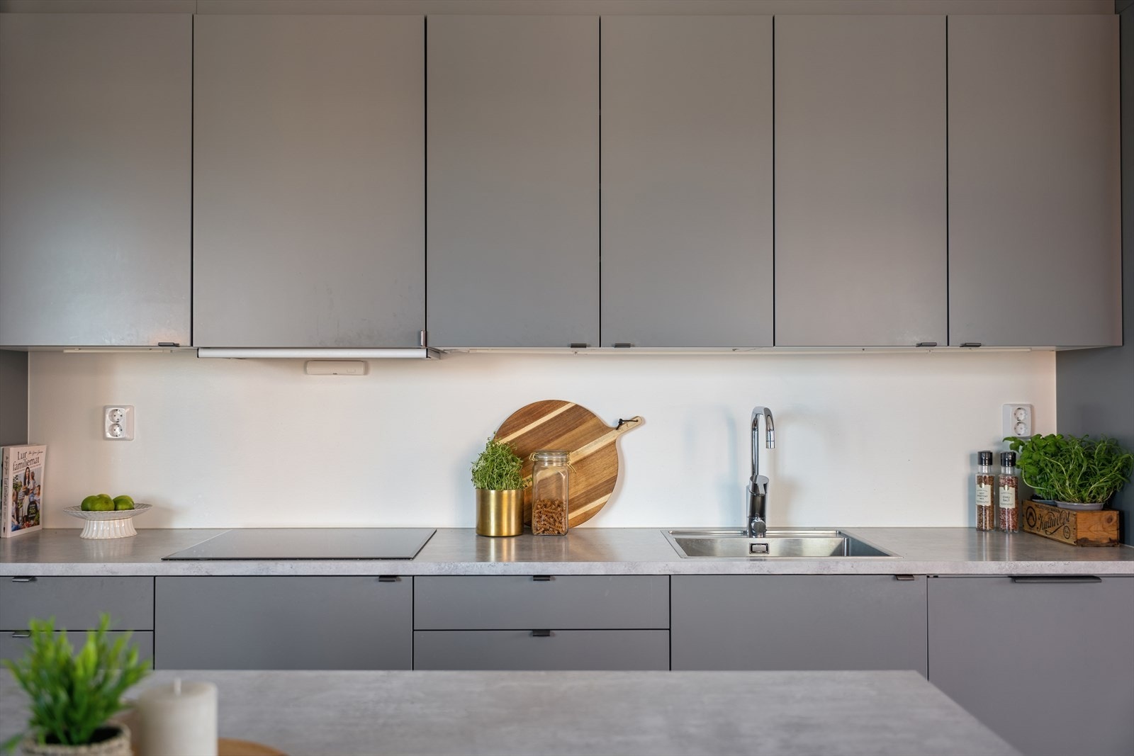 Kjøkkenet fremstår moderne med fabrikklakkerte fronter, laminert benkeplate og gode oppbevaringsmuligheter med takhøye overskap. Galleribilde