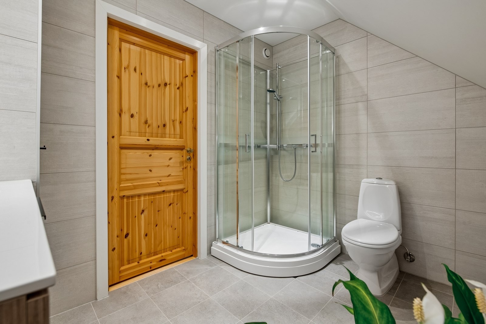 Badet inneholder benk med heldekkende vask, speil m/bakgrunnslys, frittstående klosett og dusjkabinett. Galleribilde