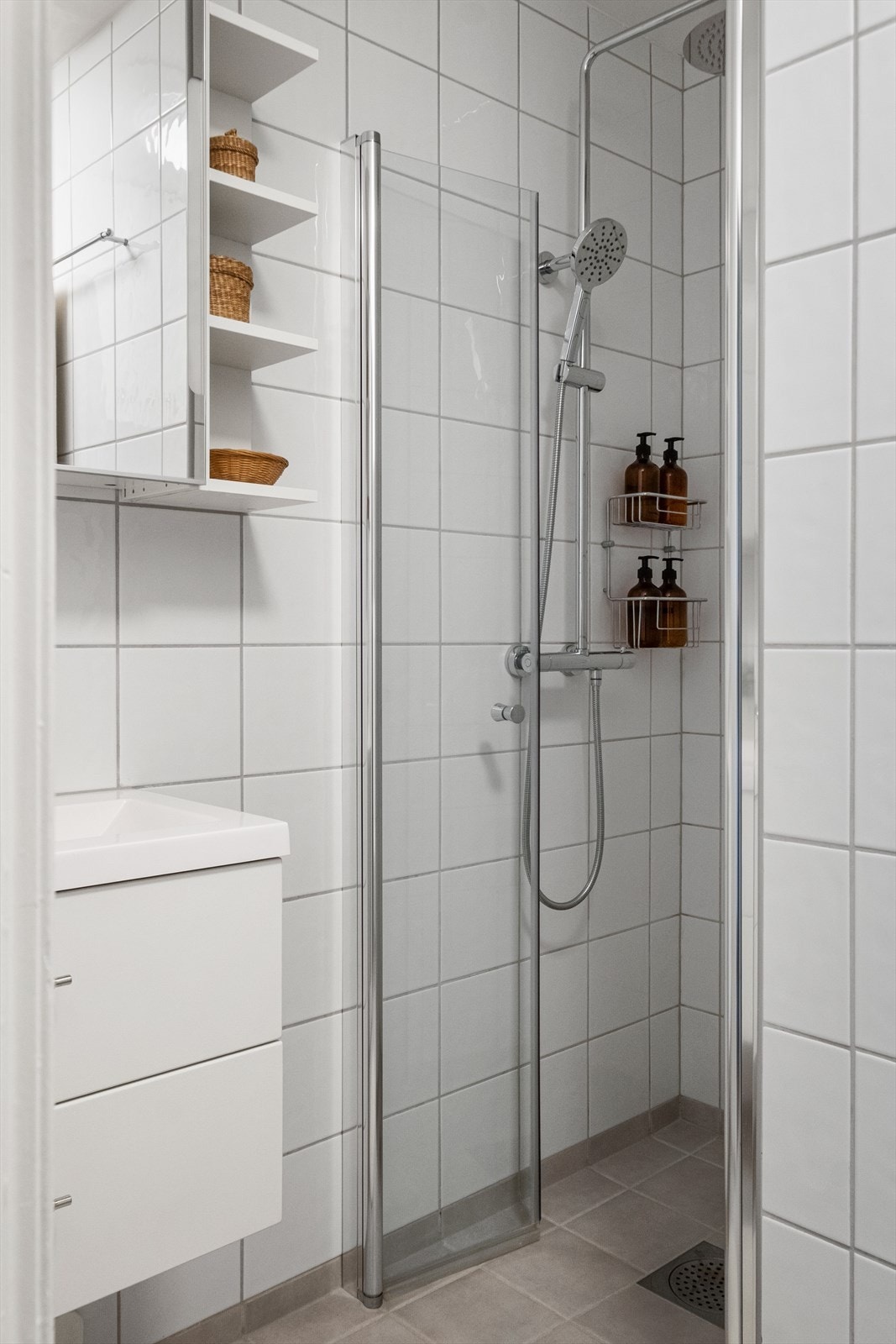 Badet er innredet med servant med skuffinnredning, overskap med speil, vegghengt toalett og dusjløsning. Ny dusjarmatur med blandebatteri fra Noro baderom satt inn i 2026. Galleribilde
