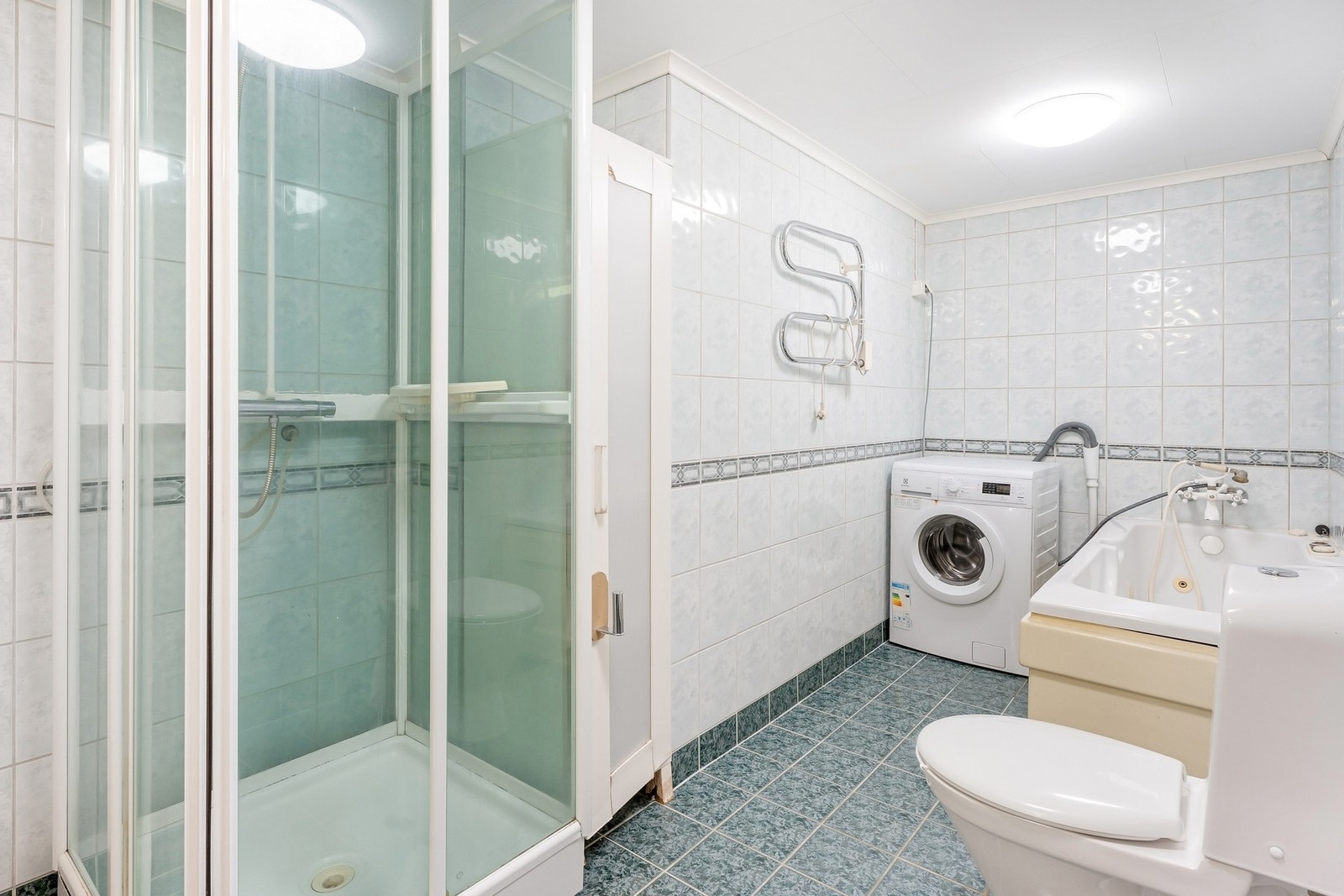 Bad innredet med dusjkabinet, badekar, servant og WC. Galleribilde