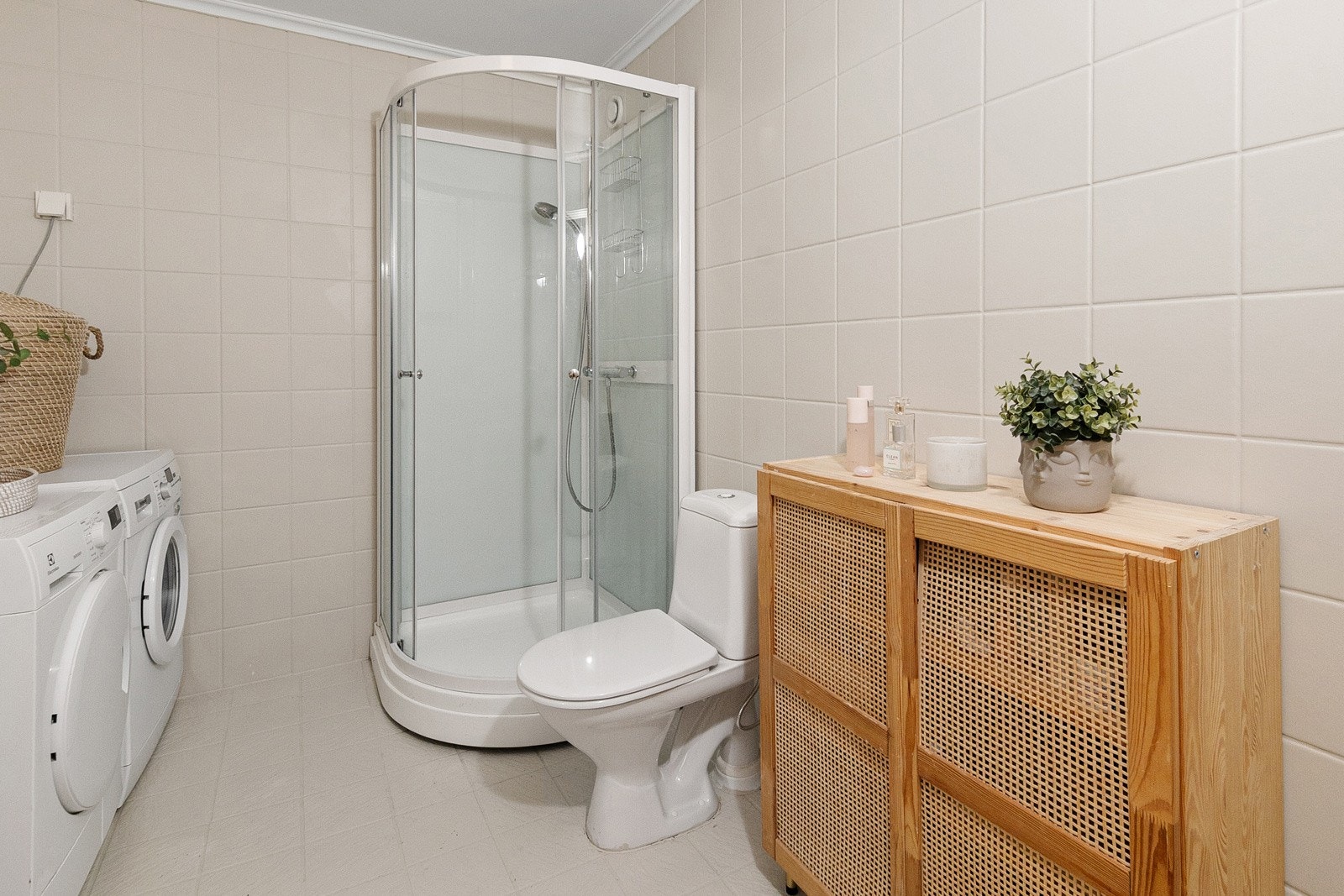 Badet har servant i romslig innredning, dusjkabinett, toalett og opplegg for vaskemaskin/tørketrommel Galleribilde