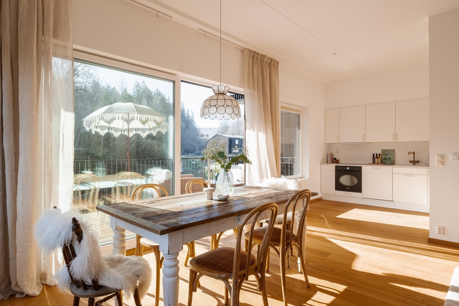 Dagslyset som strømmer inn via de store vinduene gjenspeiles fint i de hvitmalte overflatene, og allrommet har parkett på gulv med vannbåren gulvvarme. Galleribilde