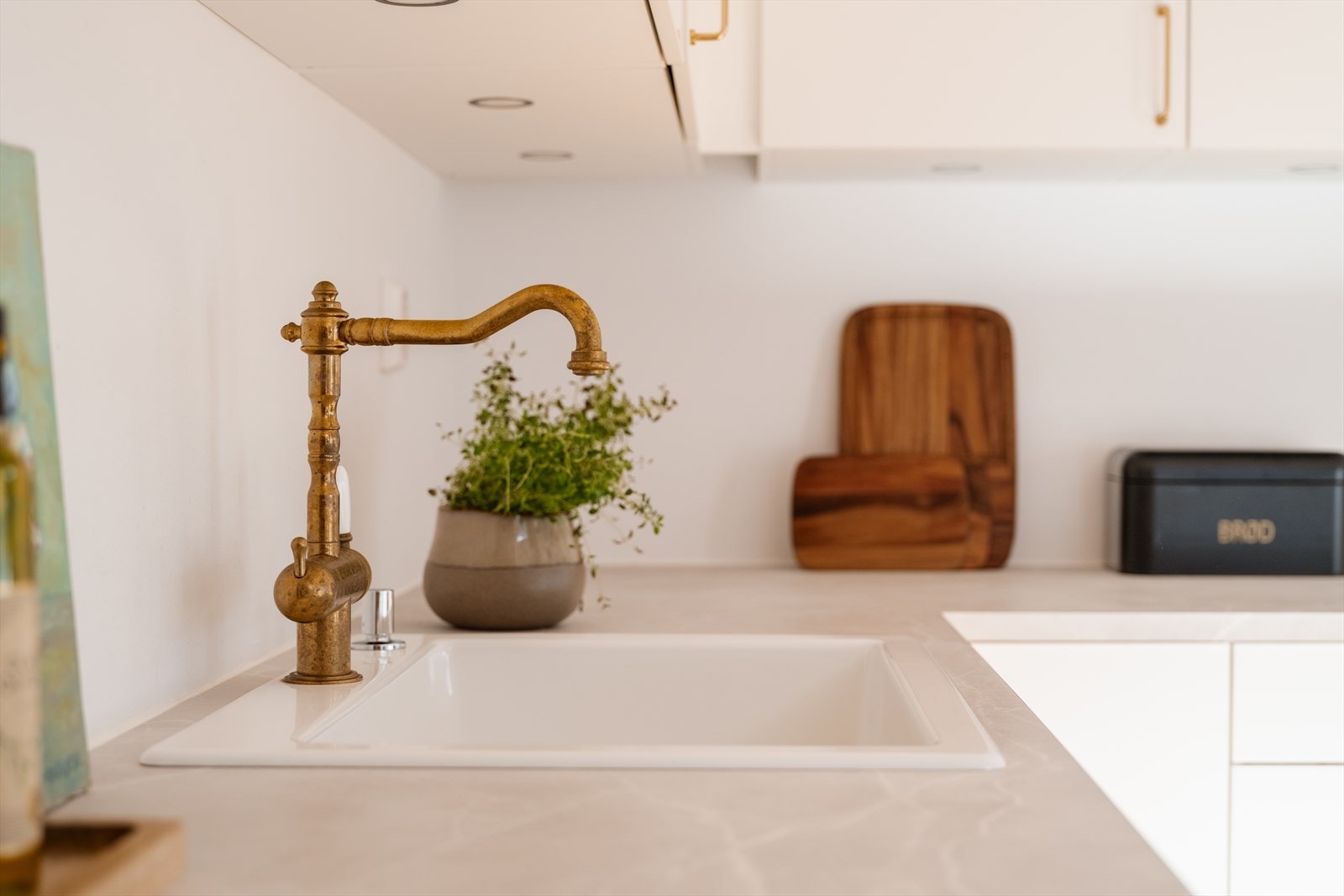 Det er lys laminatbenkeplate med nedfelt, hvit kum i porselen. Galleribilde