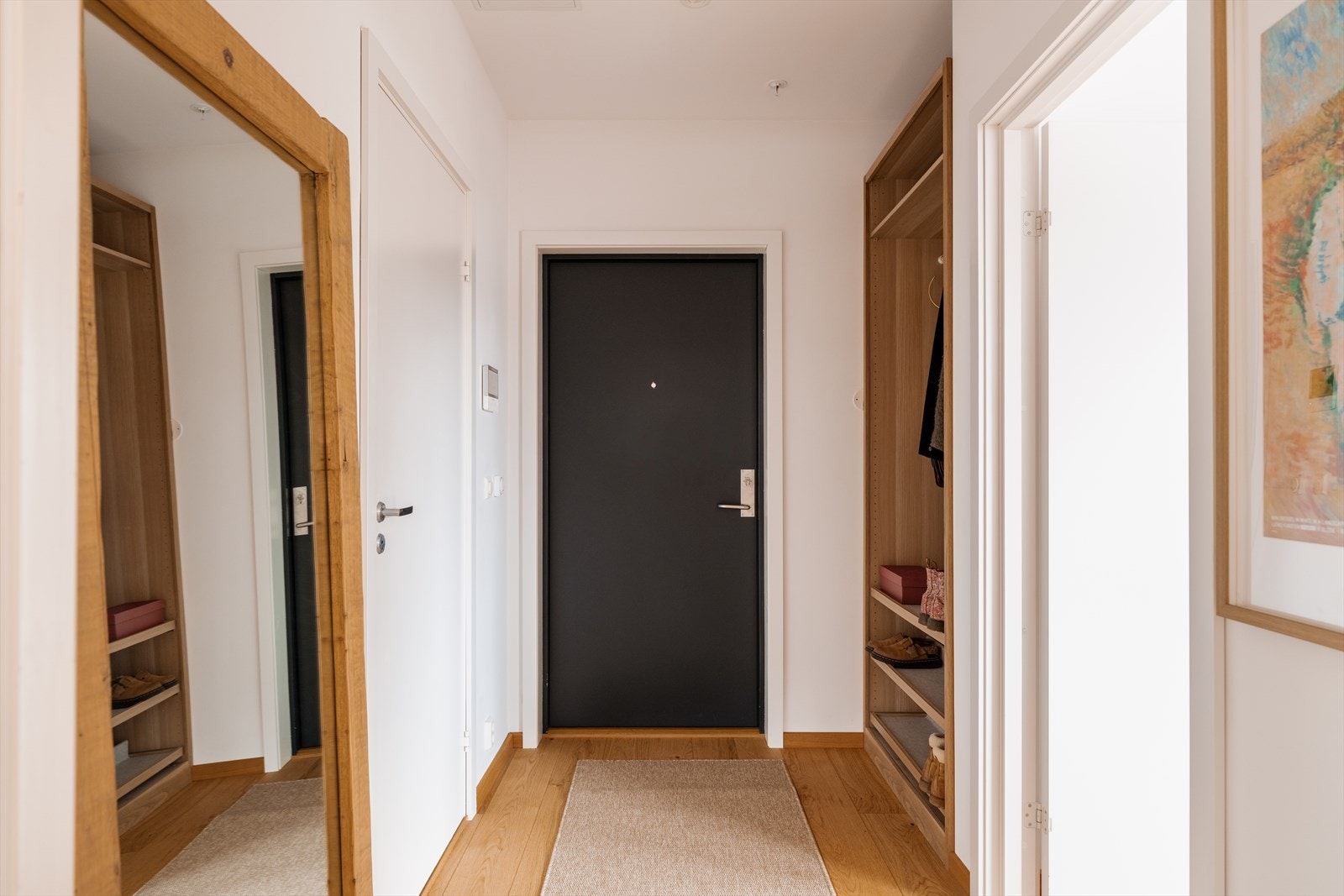 I entréen er det en åpen garderobeløsning i en nisje, og det er montert dørcalling med åpner ved inngangsdøren. Galleribilde