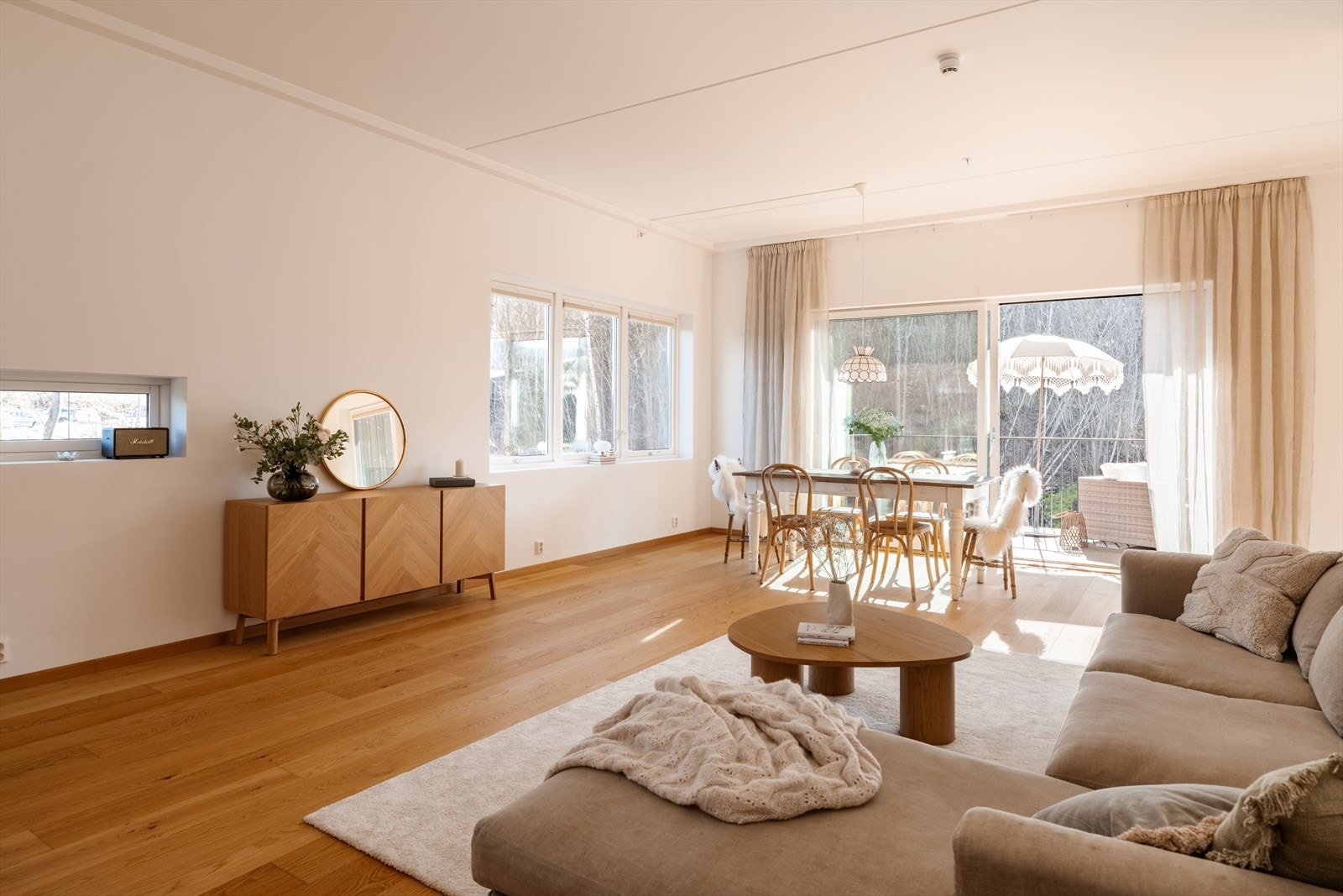 Stuen ligger i åpen løsning med kjøkkenet, og sammen skaper de et luftig og innbydende allrom med rikelig naturlig lys. Galleribilde