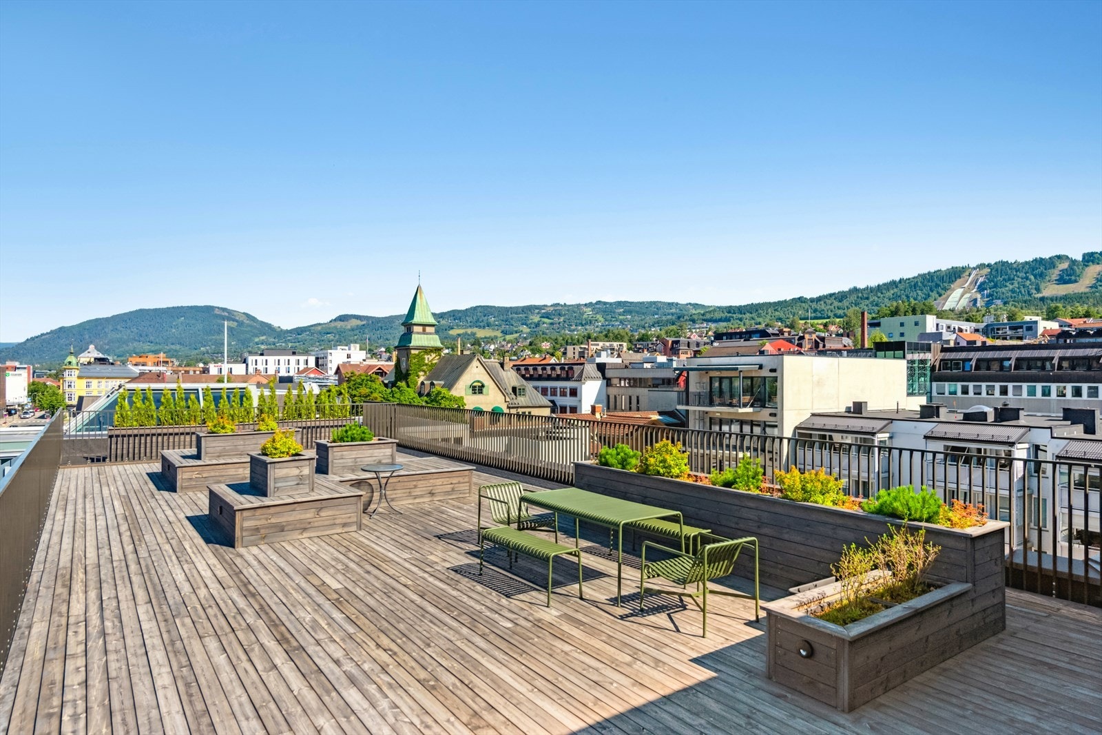 Den store takterrassen er møblert med flere sittegrupper og plantekasser. Galleribilde