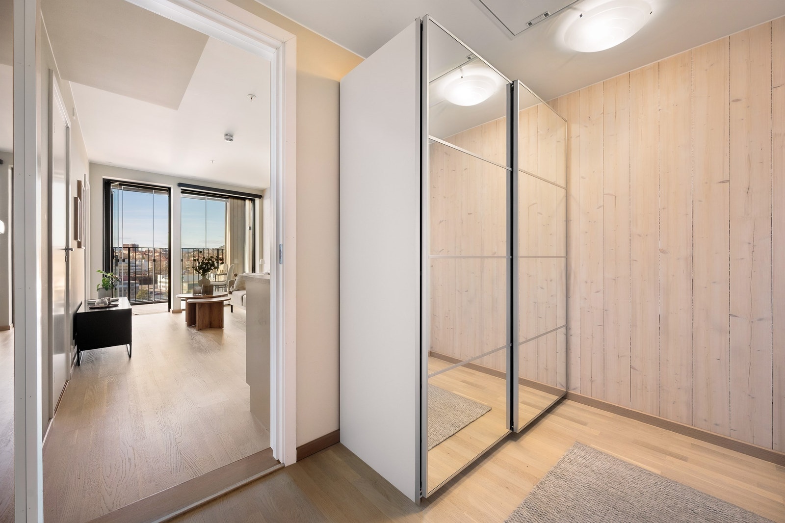 Praktisk entré med god lagringsplass i romslig skyvedørsgarderobe med store speildører Galleribilde