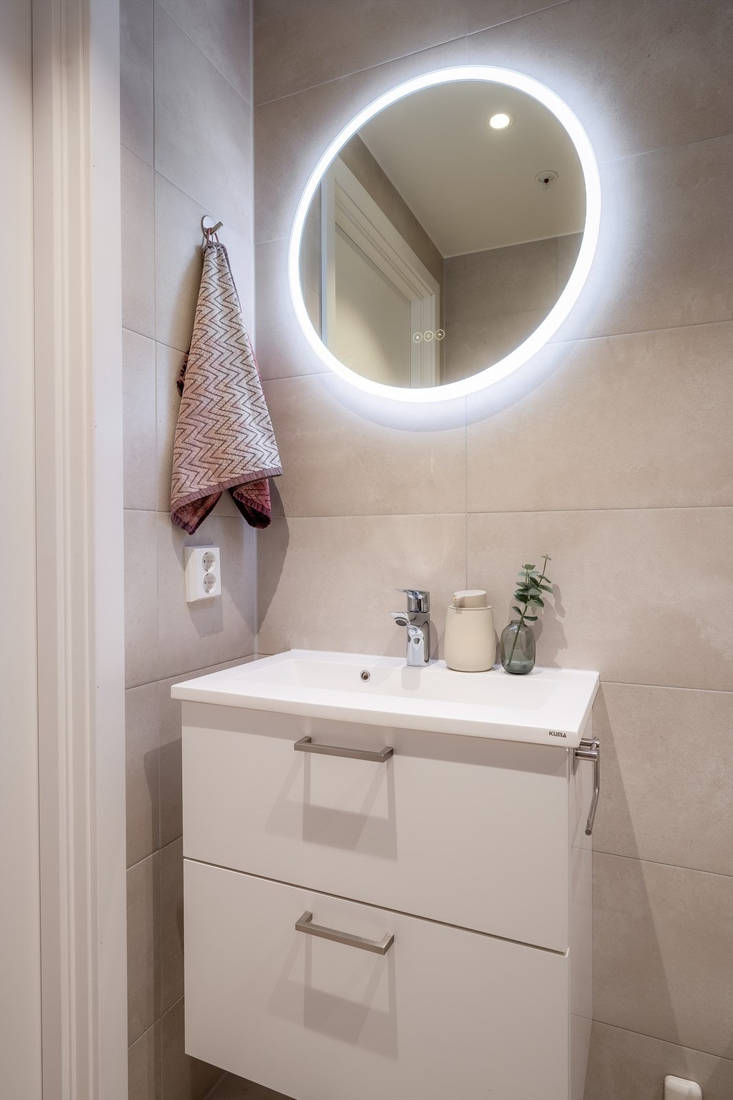 Badet er innredet med vegghengt servant m/ skuffeinnredning og toalett, speil med lys og dusjhjørne med innfellbare glassdører Galleribilde